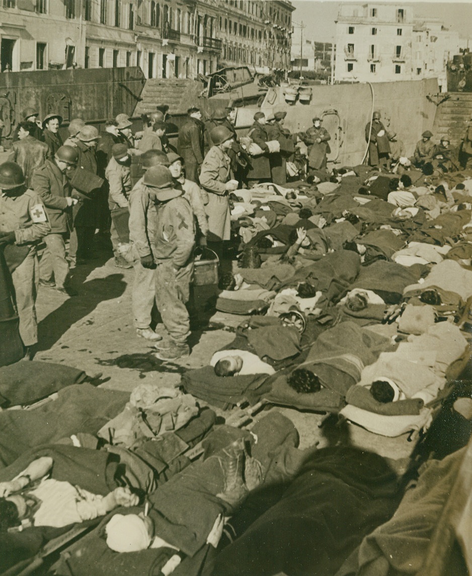 ANZIO BEACHHEAD COST, 2/28/1944. ANZIO, ITALY—Lying along the deck of a landing craft for the trip out to a hospital ship out in the harbor here, are some of the casualties from the fierce battle for the Anzio beachhead. Credit: Official U.S. Navy photo from Acme;
