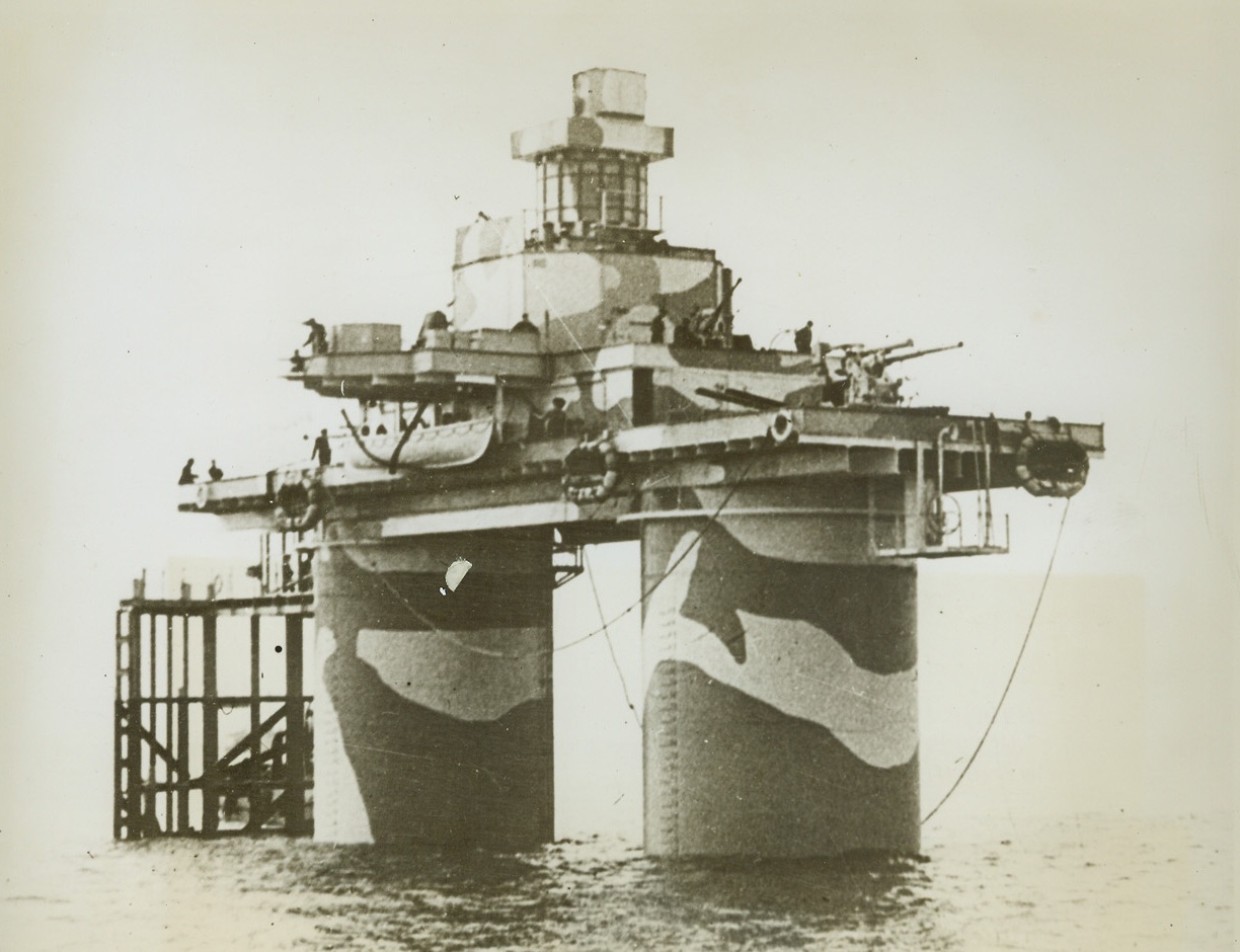 ”Island Forts” Protect British Shipping, 2/2/1944. On the British Coast – Manned by Royal Marines, “Island Forts” like this one are protecting Britain’s east coast. Each fort consists of two concrete towers, 50 feet high, connected by a superstructure on which ack-ack guns and equipment are mounted. Commissioned as H.M. ships, the forts have accounted for a number of German aircraft. Credit: ACME;