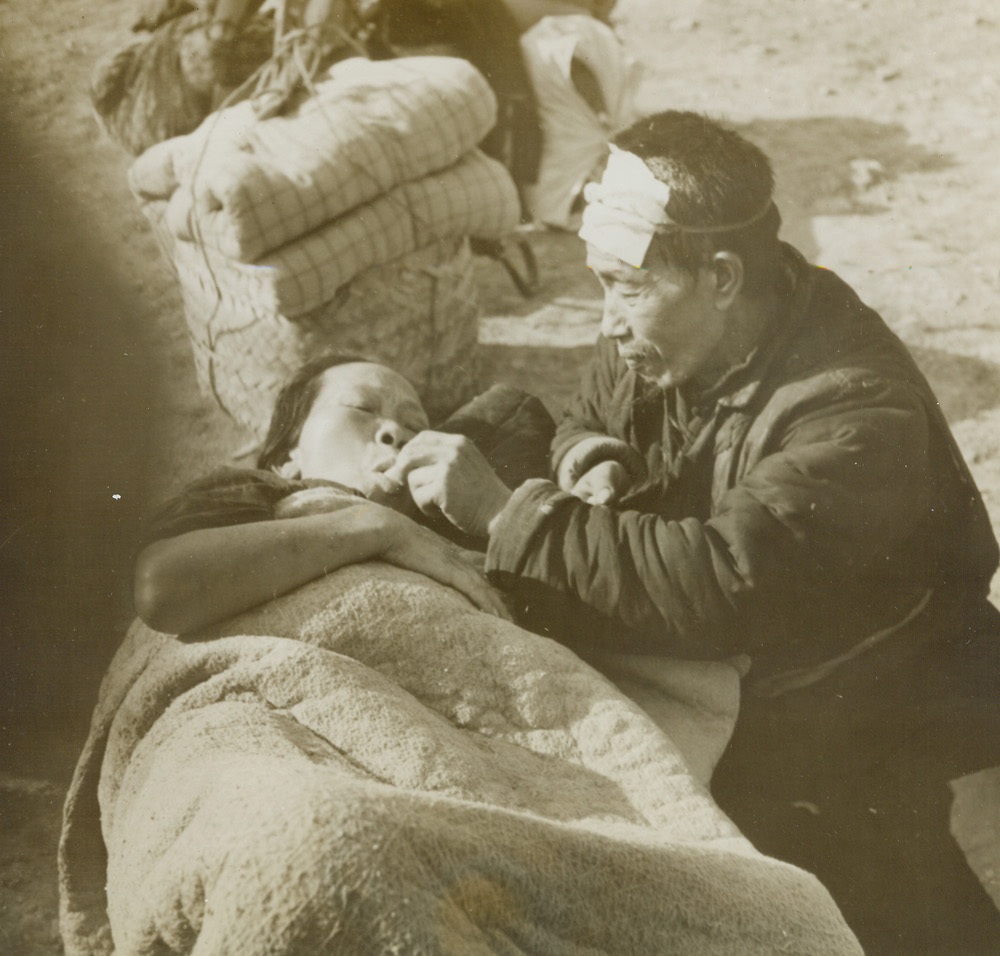 War’s Victims, 2/2/1944. Changteh, China – While waiting for aid from relief organizations set up at Changteh after Chinese fighters drove the Japs from that city. An old man cares for his ill wife. Both were innocent victims of the terrific fight for the key city, from which the enemy was chased on December 9, 1943, six days after the Japs first took Changteh. Credit: ACME;