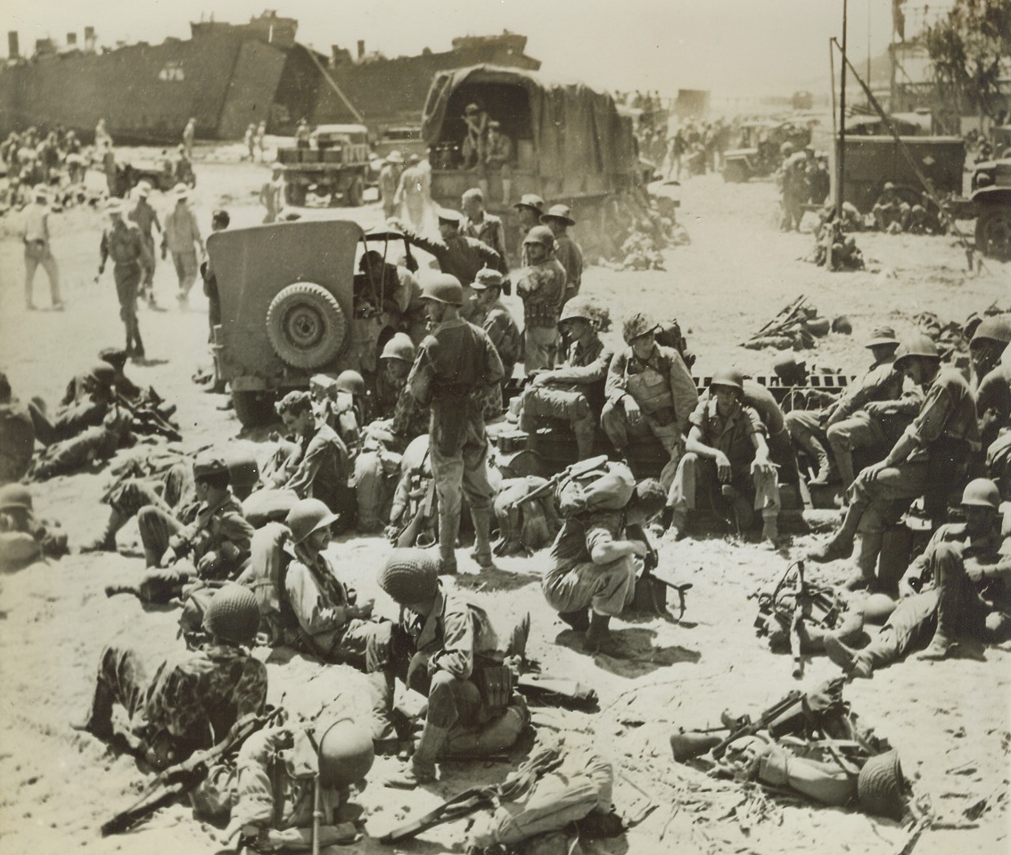 Pre-Assault Rest, 2/1/1944. Cape Gloucester – Marines take it easy prior to boarding an LST at an advance base for their assault on New Britain Island where they took the Cape Gloucester airfields from the Japs. Credit: Marine Corps photo from ACME;