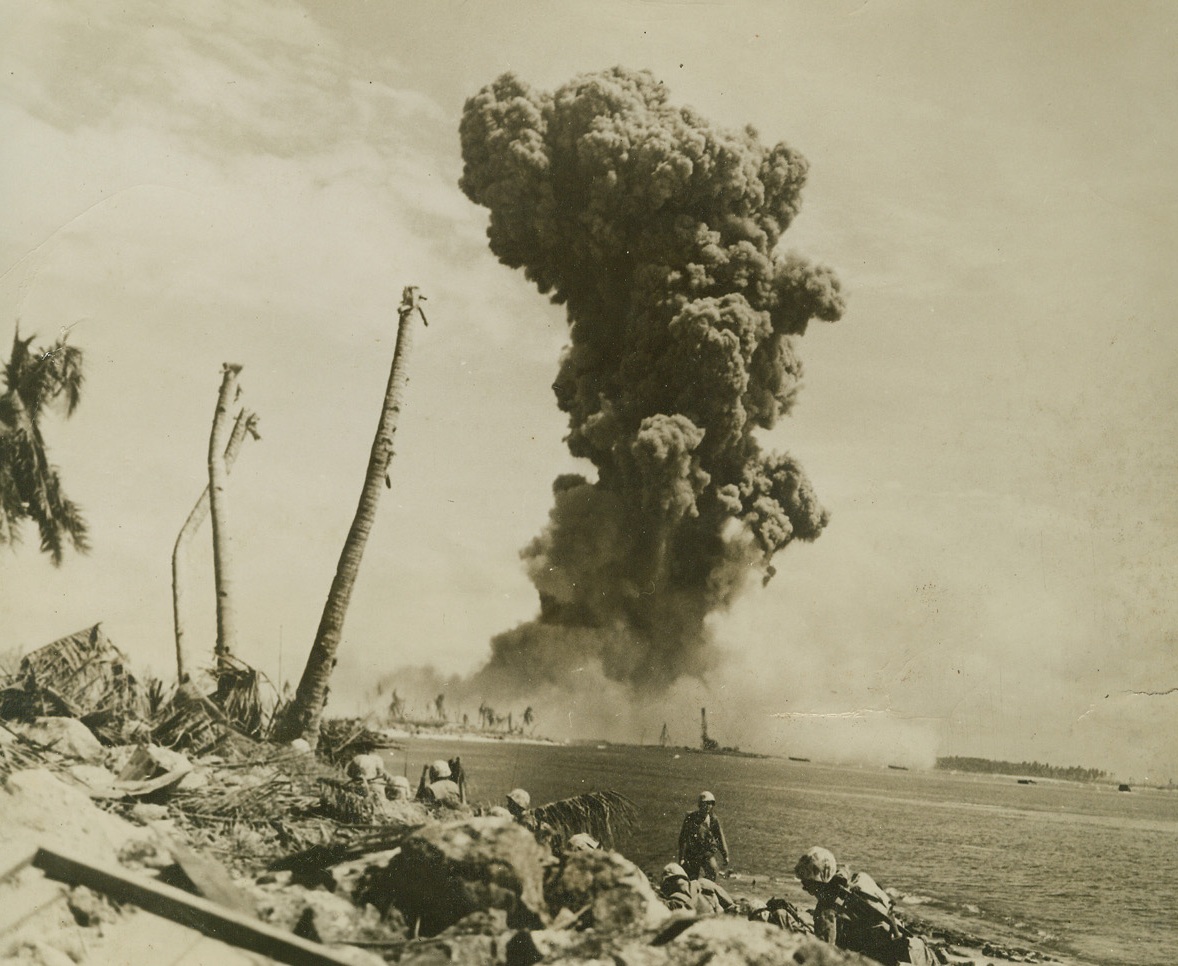 Black Clouds for Tokyo, 2/13/1944. Namur – Jap installations go skyward in the form of smoke as Marine demolition squads do the job on Namur. More Marines return enemy sniper fire on nearby Roi Island beach in foreground. Credit: Official U.S. Marine Corps photo from ACME;