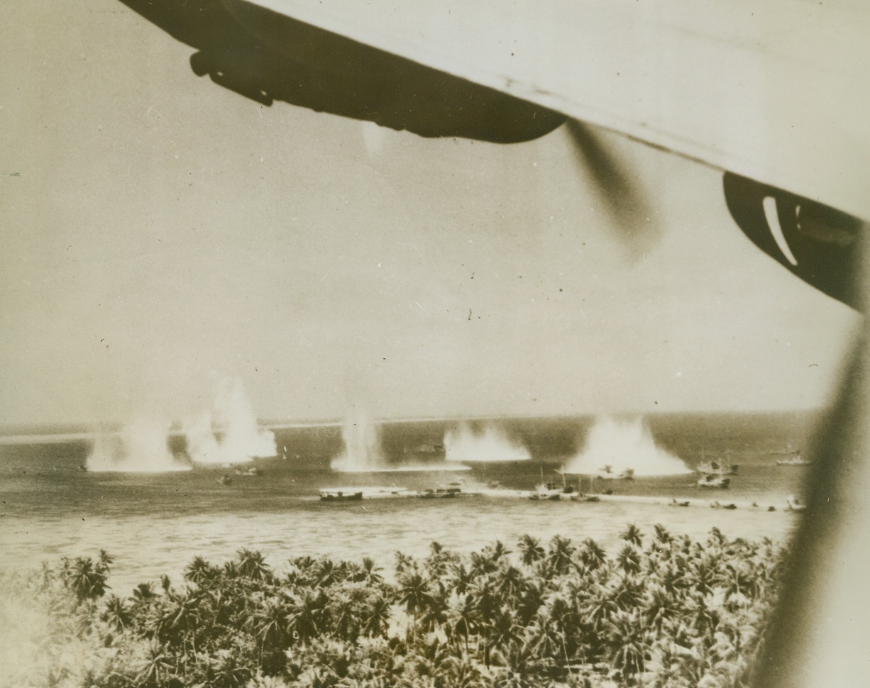 Pre-Invasion Blast at Jap Ships, 2/15/1944. Marshall Islands – Japs ships at Kwajalein atoll are rocked by bombs, as U.S. Navy planes to Marine and Army infantry invasion.  The plane from which the picture was taken banks sharply to return to the attack, its wing at upper right.Credit (U.S. Navy photo from ACME);