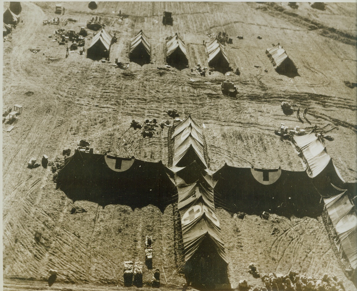 No Mistaking Hospital Markings, 2/11/1944. ITALY -- Red crosses on white backgrounds plainly mark an American field hospital outside of Nettuno; the type of tent hospital twice bombed by the Nazis in the past few days. On February 10, the Germans killed two women nurses and wounded four medical officers and three enlisted patients during an early evening bombing. Credit (ACME Photo by Charles Seawood, War Pool Correspondent);