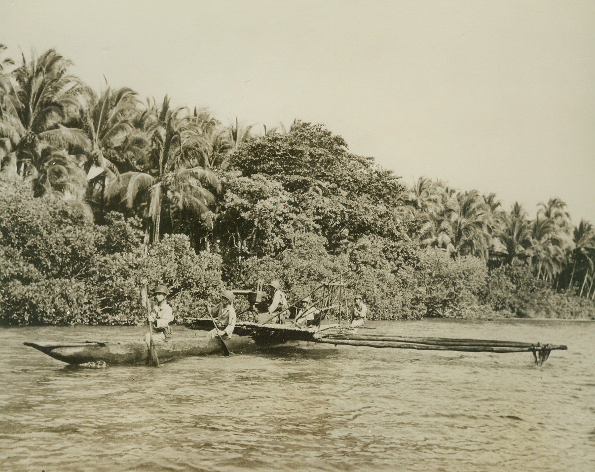 New Britain Paddle-Patrol, 2/14/1944. New Britain – U.S. infantrymen go native with a genuine outrigger canoe as they patrol the coast line of New Britain in reconnaissance of enemy positions at Arawe.  A heavy machine gun is mounted amidships, just in case. Credit (Signal Corps photo from ACME);