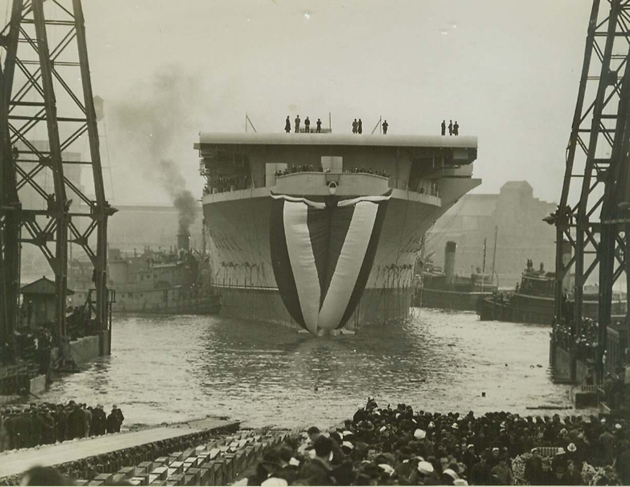 “Shangri-La Goes to Sea”, 2/24/1944. Norfolk, Va.—Jugs cluster about the 27,000-ton aircraft carrier “Shangri-La” after the flat-top was launched at the Norfolk Navy Yard where it was built at a cost of 866,000,000. Tokyo remembers the mythical airbase “Shangri-La” which turned out to be the U.S. carrier “Hornet,” and will be hearing from the new floating threat. Credit: ACME.;