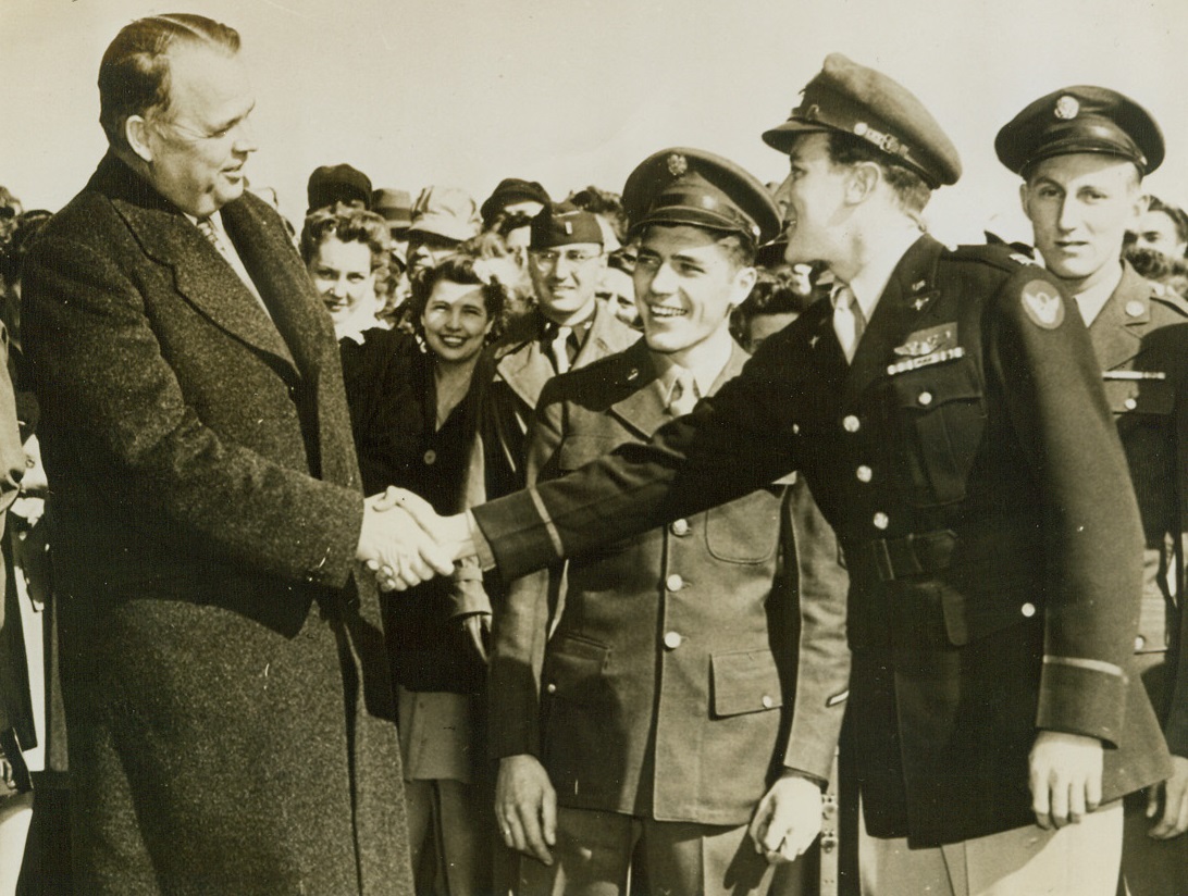 Shakes Hand That Piloted Ship, 2/6/1944. Oklahoma City, Okla. - Oklahoma’s Governor, Robert S. Kerr, welcomes Capt. John R. Johnson, pilot of the famed Flying Fortress Hell’s Angels and veteran of European combat missions, while S. Sgt. Edward W. West Jr. and M. Sgt. Fabian S. Folmer back him up. Ground and combat crews of the ship were reunited at Tinker Field, Oklahoma City, when the ship arrived there to start on a War Loan tour. Credit: ACME;
