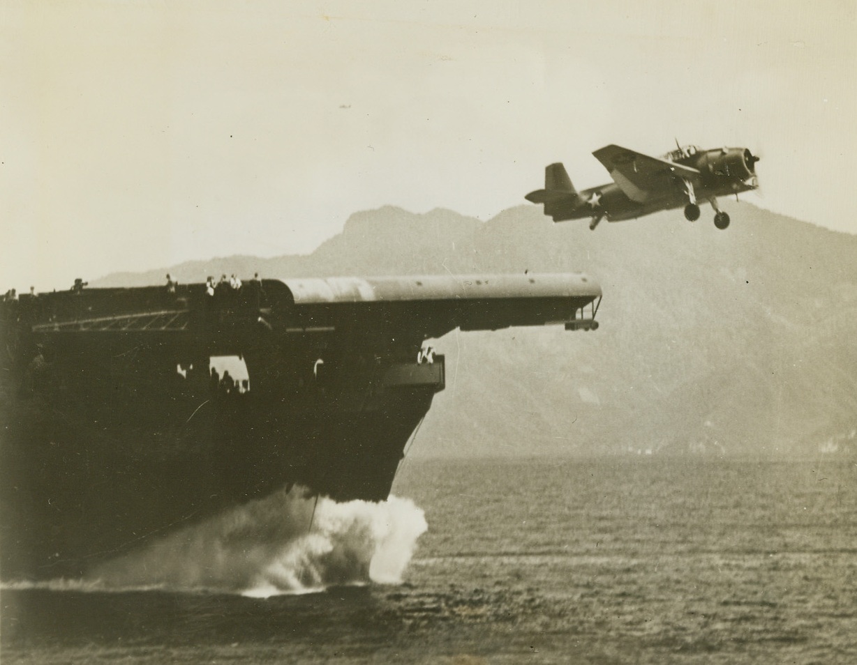 An “Avenger” Awing, 2/1/1944. This photo, released by the Navy Department in Washington today, shows a Grumman Avenger Torpedo Bomber taking off from an American aircraft carrier “somewhere at sea.” The high, white bow wave of the warship indicated the speed with which the ship plows through a calm sea. Today, in Washington, the Navy announced that the greatest task force ever used, including carrier and land based aircraft and surface craft, had effected a U.S. landing at two points in the Marshall Islands, the first beachhead to be established in territory held by the Japs before Pearl Harbor. Credit: U.S. Navy photo from ACME;