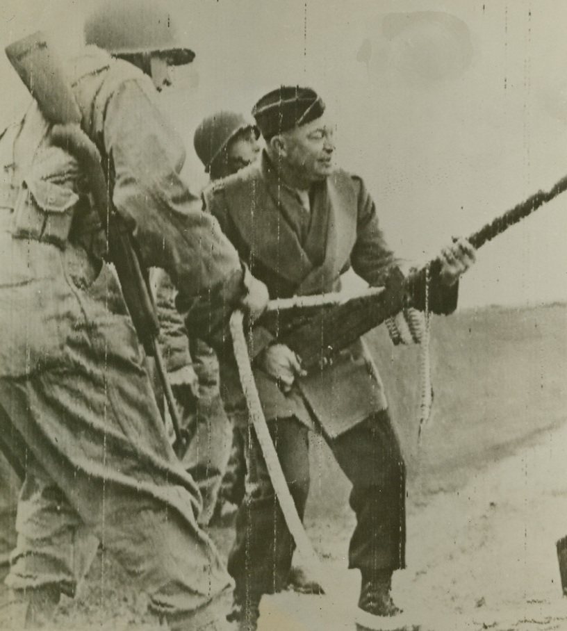 Hasn’t Lost His Touch, 2/18/1944. Somewhere in England - Inspecting an Infantry Unit somewhere in England, General Dwight D. Eisenhower shows his men that he hasn’t’ lost his Doughboy touch. Using a Browning Machine Gun - off its mount - he shoots from his hip. Credit: ACME photo via Army Radiotelephoto;