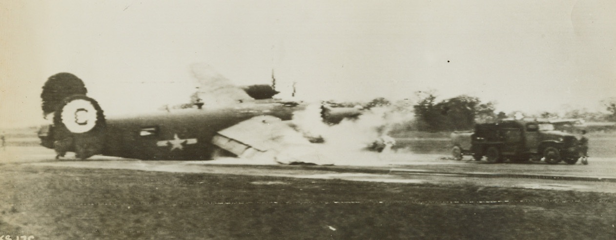Liberator in Trouble, 2/18/1944. Somewhere in England - Returning to its base somewhere in England, a Liberator Bomber crash-lands and catches fire. Piloted by Lt. Claude E. White of Tushka, Okla., the ship came in with only one wheel and the propeller of its #4 engine was knocked off as it hit the ground. Flames were soon doused by the station’s ground forces. Credit: U.S. Army Air Forces photo via U.S. Army Signal Corps Radiotelephoto from ACME;