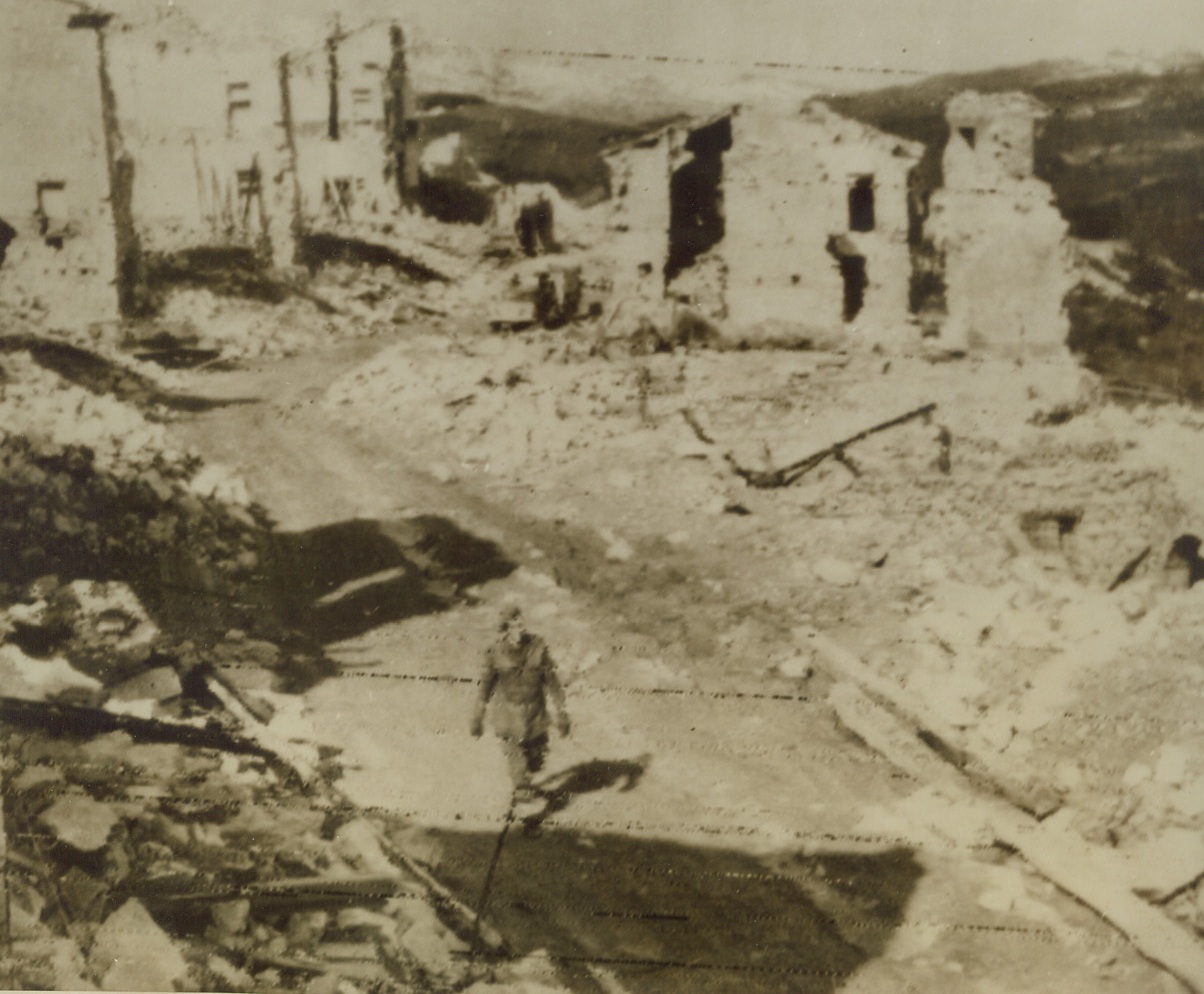 GERMANS LEAVE DESTRUCTION IN THEIR WAKE, 3/27/1944. ITALY—All that remains of this Italian city, San Pietro are ruins and destruction by the Germans shortly before their retreat from the city. An English tommy is walking among the wreckage.Credit: Acme;