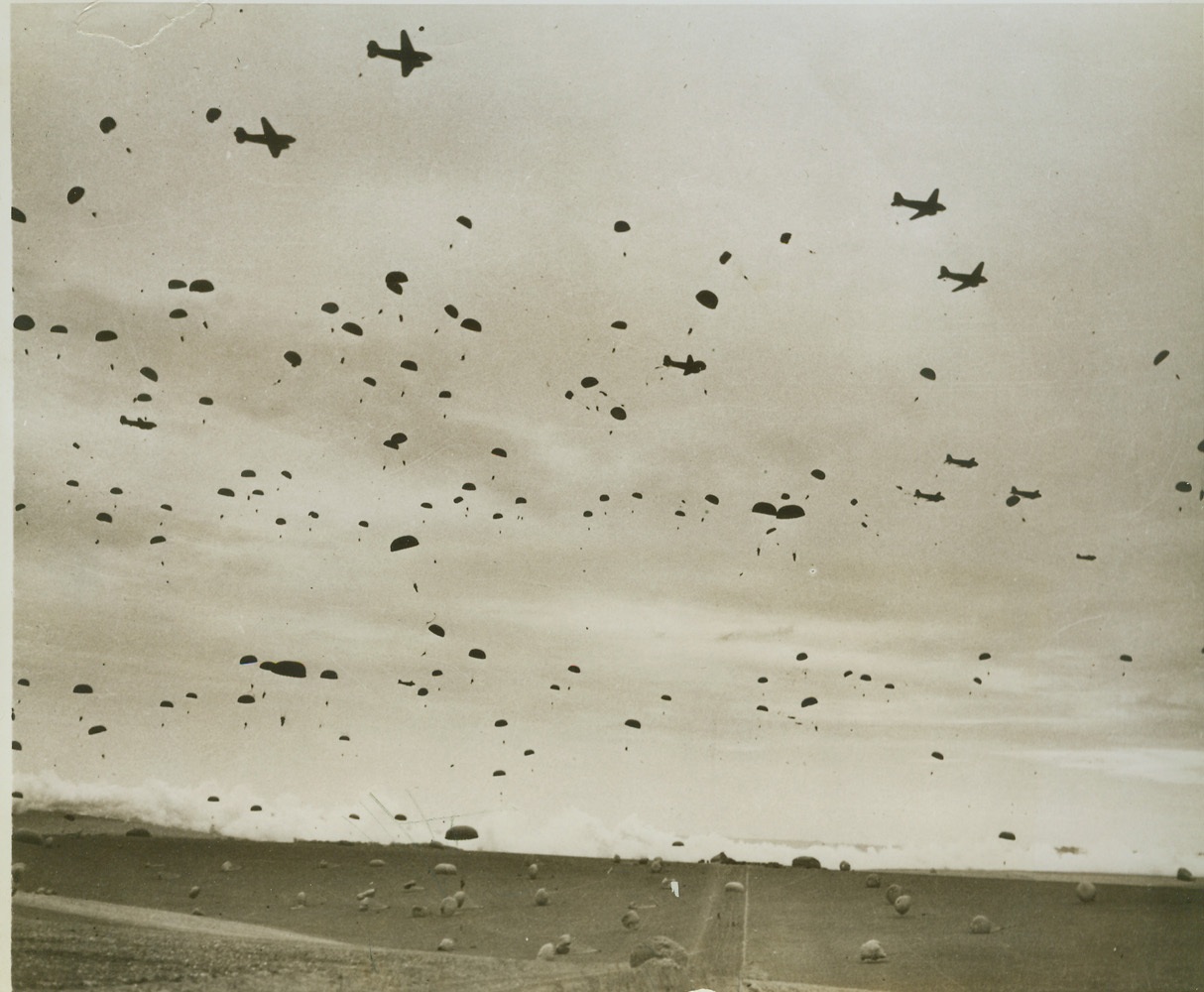 Parachute Maneuvers Over the United Kingdom, 3/31/1944. ENGLAND -- Hundreds of parachutes cover the ground and fill the air during recent maneuvers of the Ninth Air Force Troop Carrier Command in the United Kingdom. The T.C.C. transports men to combat area, evacuates wounded and carries airborne engineers and their equipment. Credit (Official AAF Photo from ACME);