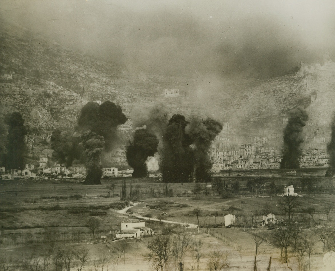 Another Pounding for Cassino, 3/29/1944. ITALY – Huge smoke columns mark exploding Allied shells and bombs in another terrific bombardment, as German troops hidden molelike in the ruins of Cassino, resist desperately the advance of Allied 5th Army forces. Some idea of the height of the smoke columns can be obtained by comparing them with buildings in the foreground. Credit Line ( U.S. Signal Corps Photo from Acme);
