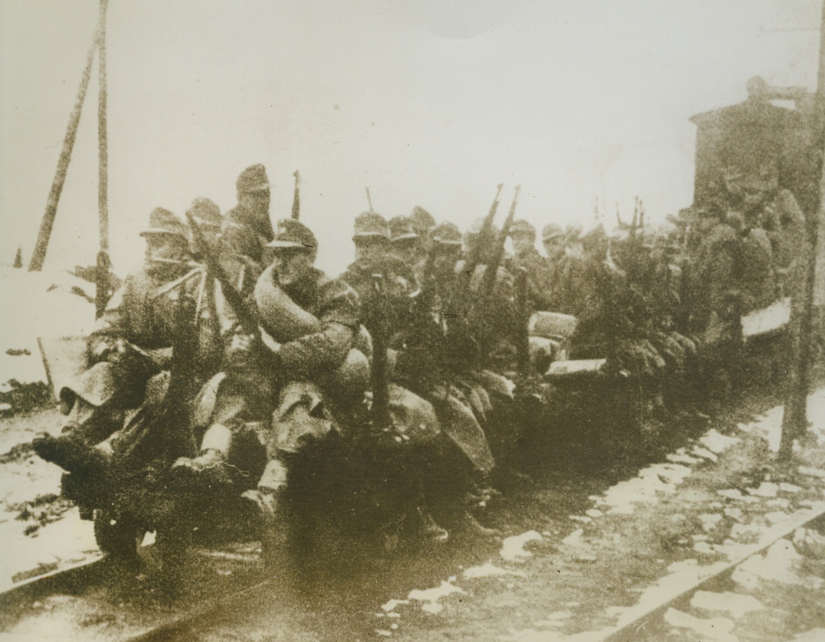 They Keep Their Eyes Peeled, 3/12/1944. YUGOSLAVIA – Never daring to turn their eyes from the surrounding countryside for fear that Yugoslav partisan fighters will catch them off guard, these Nazi infantrymen dangle their legs from a flatcar as they begin an uncomfortable journey to new positions. Fighting a losing battle against Marshal Tito’s guerillas, the Germans are constantly harassed by the Yugoslavs. Photo obtained through a neutral source.Credit Line (Acme);