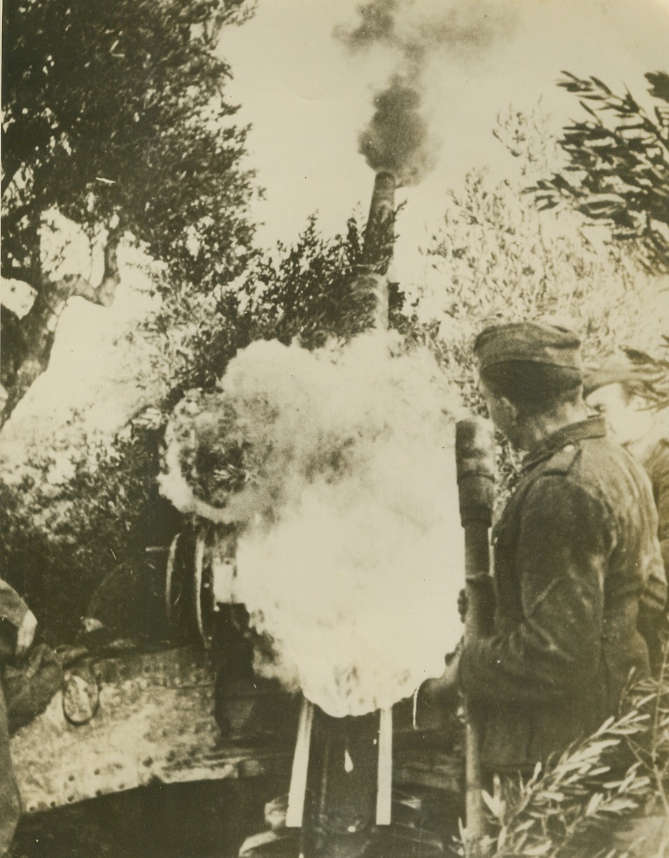 GERMAN BACKFIRE, 3/12/1944. ITALY—Smoke bursts forth from the muzzle and breech of a heavy German gun in action somewhere in Italy, according to German caption accompanying this photo received through neutral sources. This rear view of Nazi gun is symbolic of the way the Blitz turned into a slow-but-sure retreat. Credit: Acme;