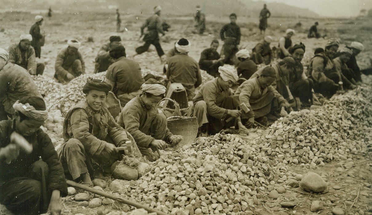 Airfield – Handmade, 3/31/1944. China – Lack of modern equipment and machinery isn’t stopping resourceful Chinese from building modern airfields in China. Three hundred thousand Chinese workers have been conscripted to do the job. A hundred thousand little handmade wheelbarrows are used to transport materials – and even the chipping of stones for the runways is done by hand. American Engineers, working in conjunction with expert Chinese Army Engineers, are supervising the job. Photo shows: A formation of Chinese workers busily chips the stones for the runway by hand.Credit: ACME photo by Frank Cancellare for the War Picture Pool;