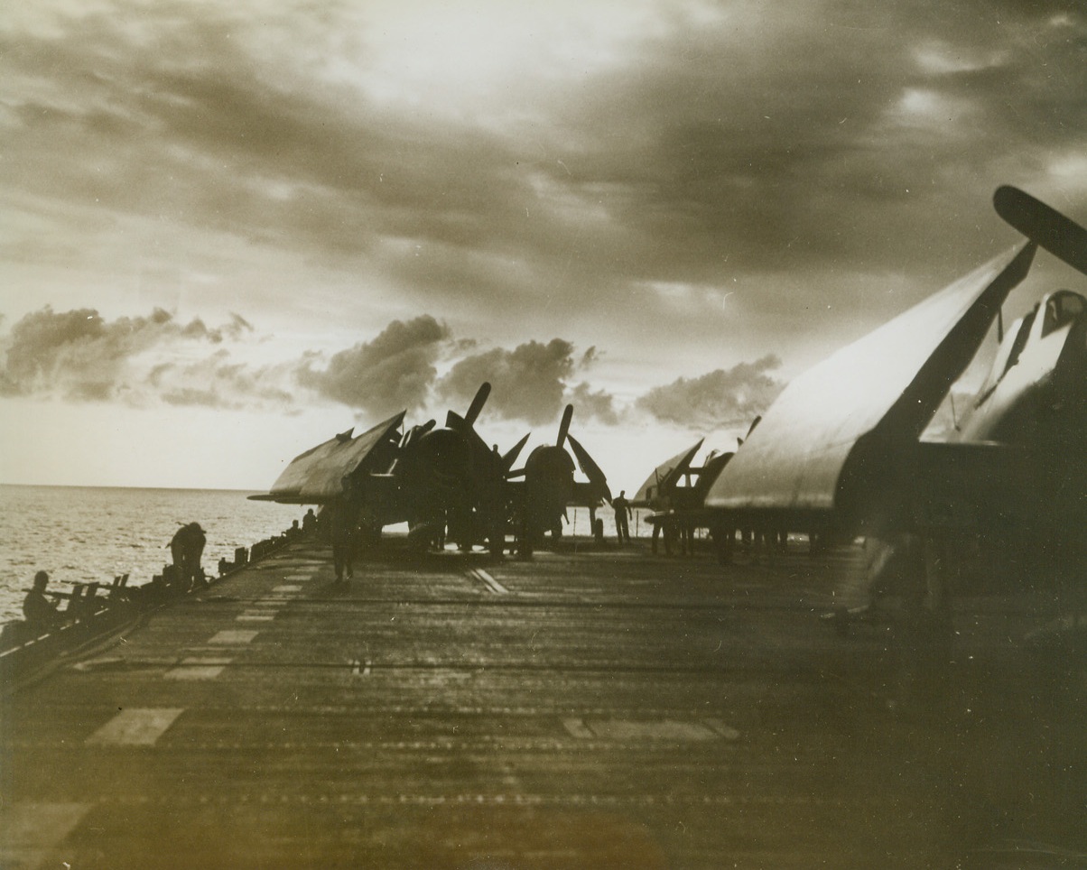War birds at Rest, 3/21/1944. Central Pacific – Silhouetted against the clouds and the sunset, these planes aboard an aircraft carrier of the U.S. Navy Pacific fleet are at rest with their wings folded.  At the first sign of action, however, they are ready for a quick takeoff. Credit Line (U.S. Navy photo from ACME);
