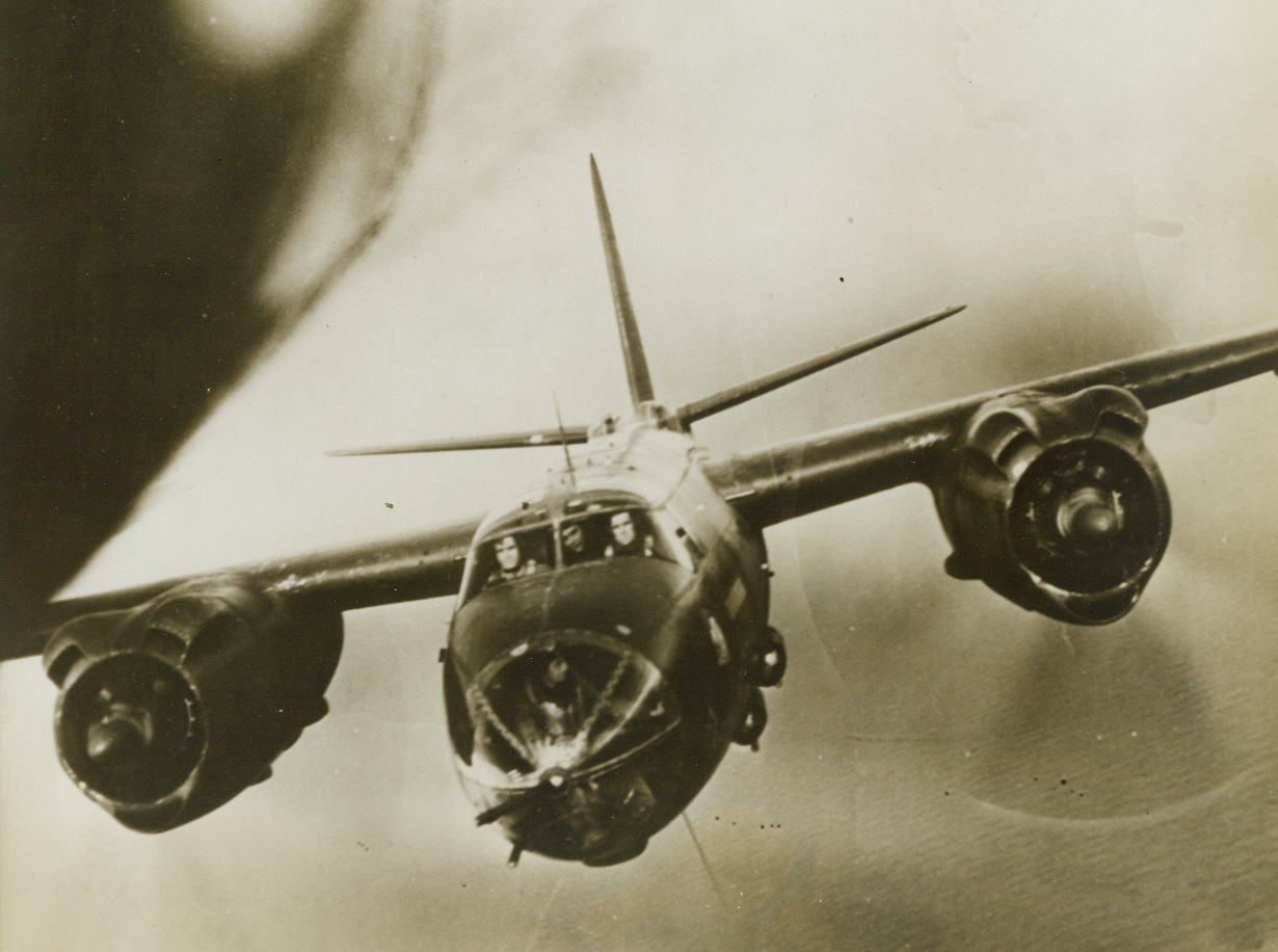 CLOSE FORMATION…BUT CLOSE!, 3/4/1944. BRITAIN—If this B-26 Marauder of the Ninth U.S. Air Force came any closer, it would be chewing off the tail of the ship before it! The medium bombers were flying in such close formation that the photographer in the ship ahead was able to make a clear photo of the crew at their stations.  Credit Line (ACME);