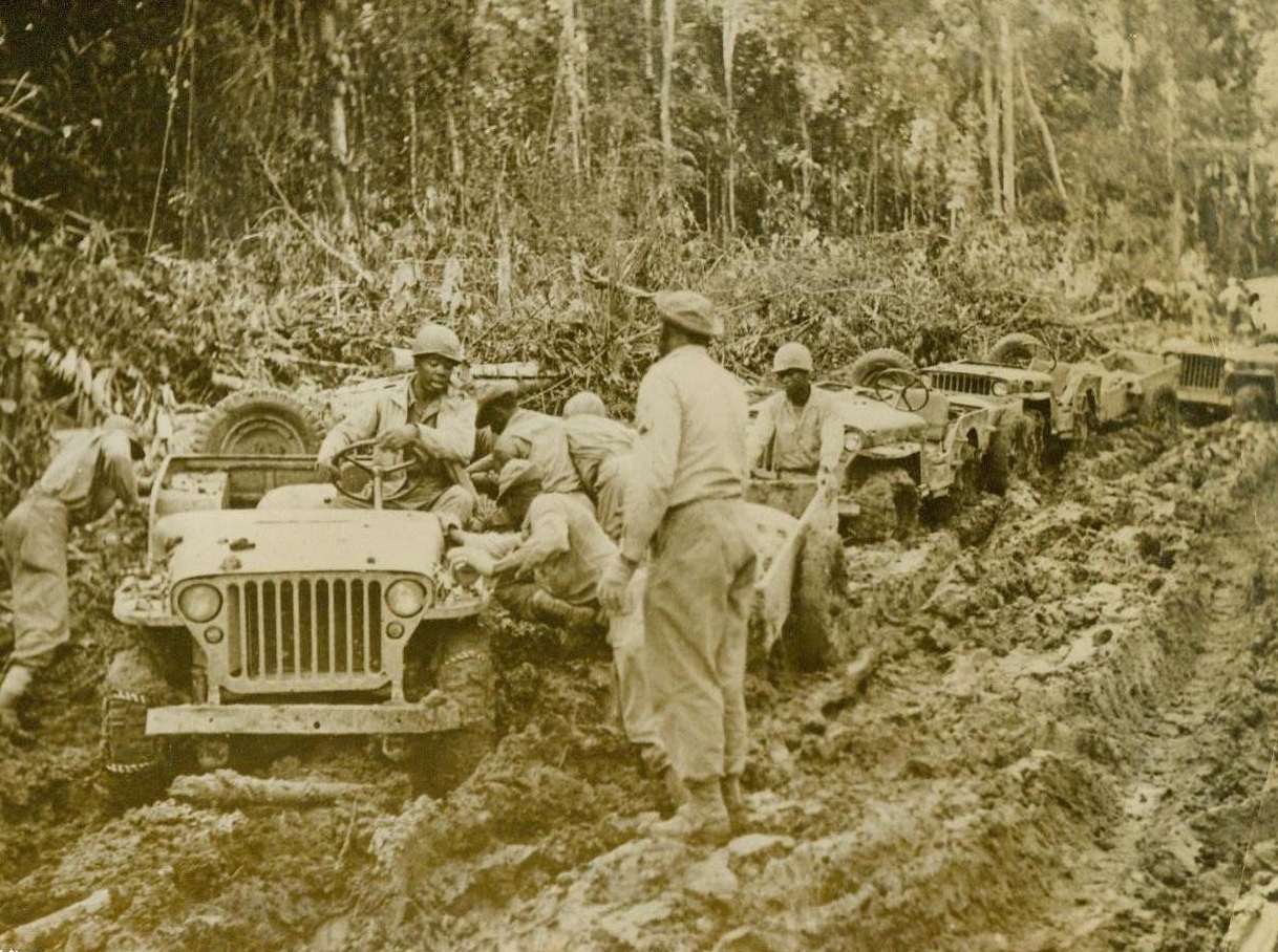 Supply Road to China-- Someday, 3/9/1944. Burma—If one Jeep bogs down in the mud of the New Ledo road, the whole caravan of blitz buggies is temporarily halted. Negro soldiers attached to an engineering Division building the supply route to China try to extricate a buggy from the deep, shifting mud on a section of the road that has just been cleared of Jungle growth. 3/9/44 Acme;