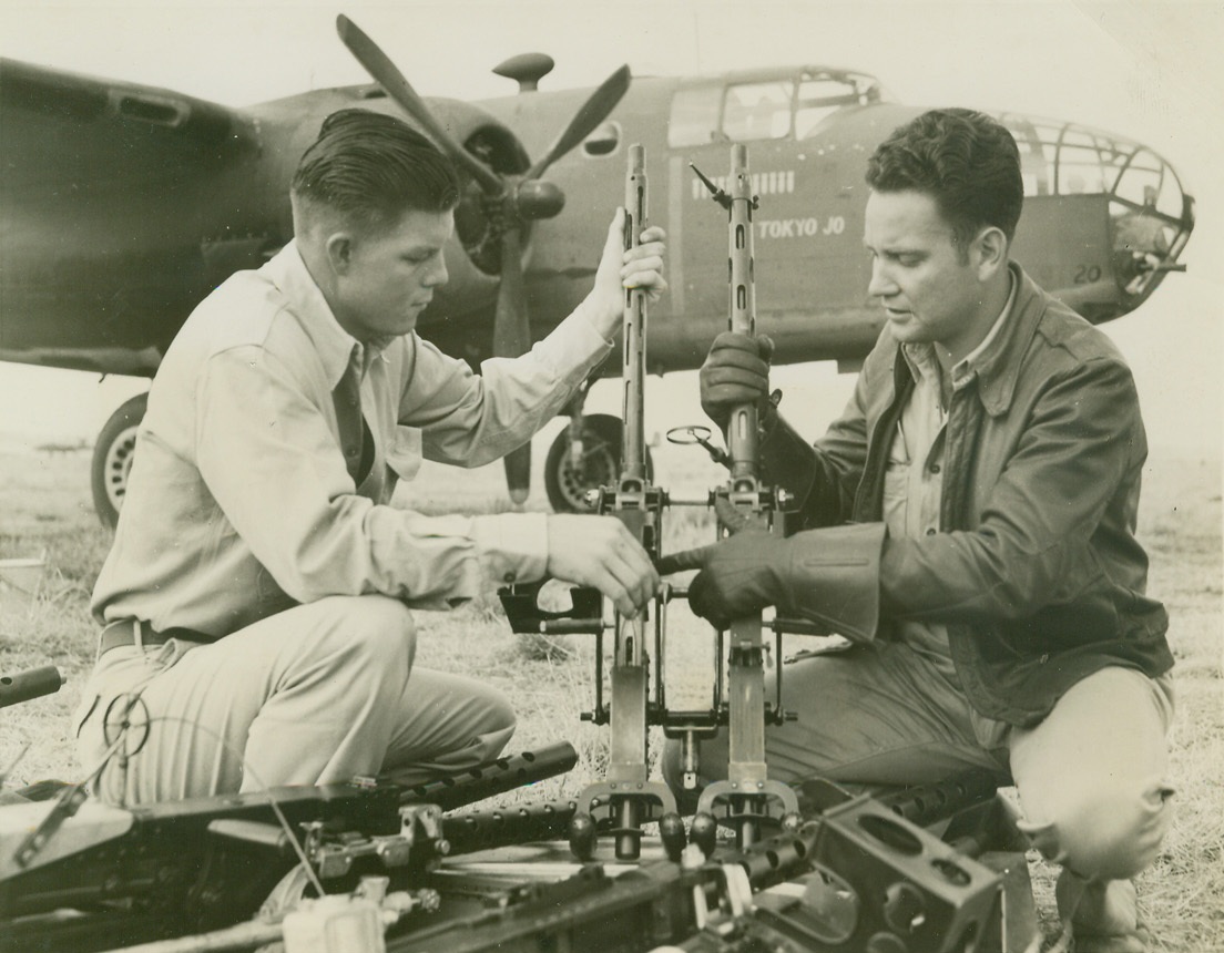 Ace Gunners Get Set For a Raid, 3/4/1944. CBI War Theater—Judged two of the leading gunners of all U.S. bomber crews in China, T/Sgt. Norton G. Stubblefield, of Dallas, Tex., (left) and T/Sgt. Adam R. Williams, of Morgantown, N.C., put their 50 caliber machine guns in top working order before a raid. Sgt. Stubblefield holds the Silver Star, and Sgt. Williams, veteran of the Tokyo mission, has the DFC, Silver Star and a Chinese decoration called “Order of the Clouds.”  Credit: ACME photo by Frank Cancellare, war pool correspondent;