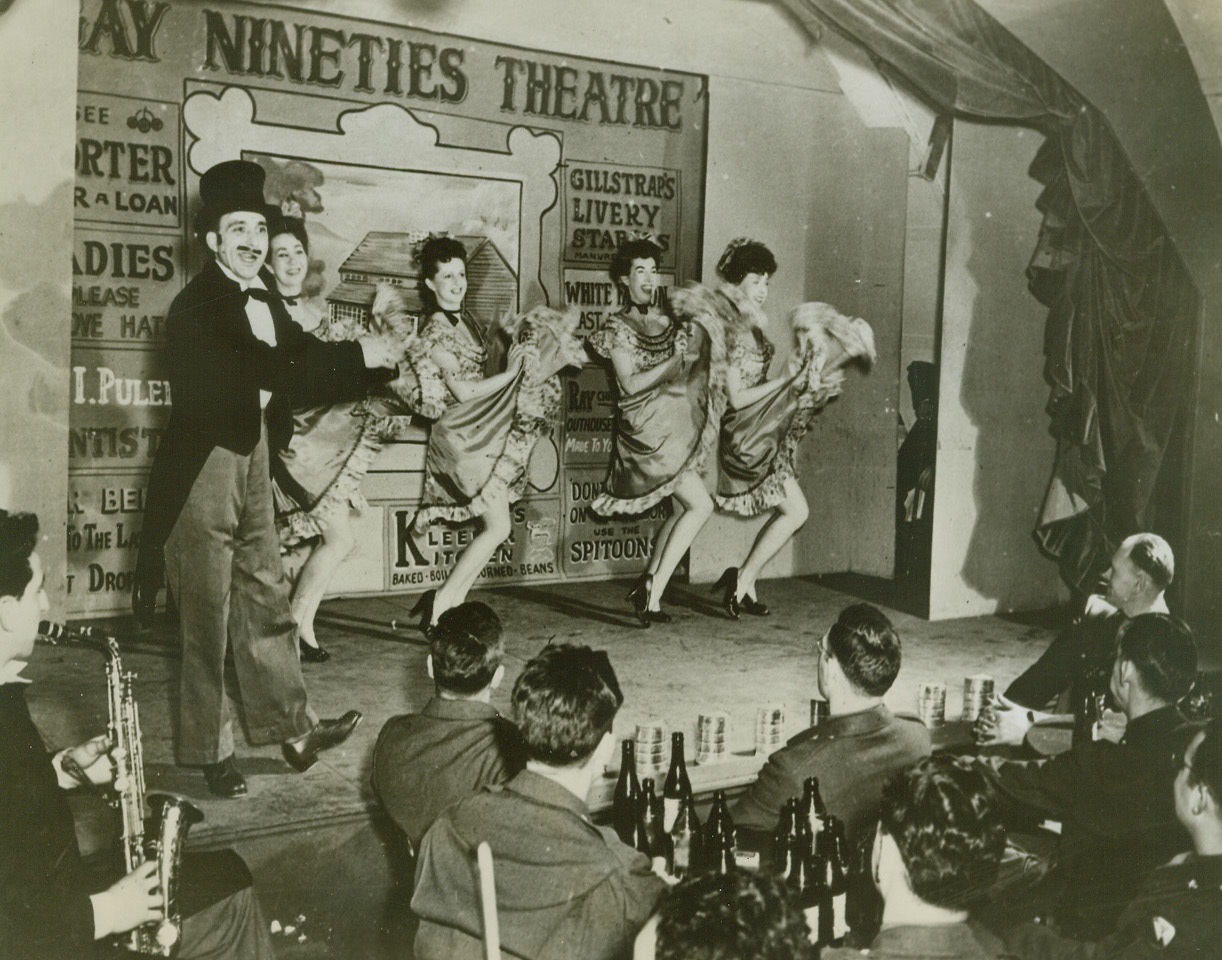 The “Nineties” Reach Iceland, 4/24/1944. Iceland—Under USO auspices “The Doughgirls and the Drunkard,” a melodrama with music, staged a six-months engagement at a base in Iceland. On stage (left to right) are: Pvt. Michael Eppolito, N.Y.C.; Miriam Stovall, Vienna, Ga.; Betty McCabe, Boston, Mass.; Molly Dodd, Hollywood, Calif.; and Parker McCormick, N.Y.C. Throughout their entire stay, the girls were never at a loss for an enthusiastic audience. Credit: ACME.;