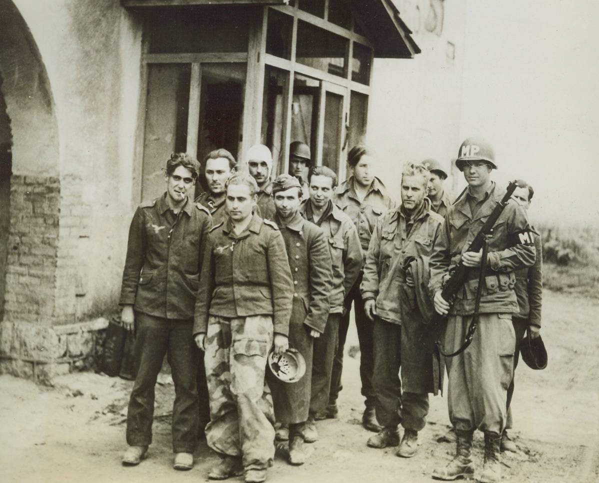 They Won’t Do Hitler Any Good Now, 4/30/1944. ITALY—Looking a little sheepish, but not at all despondent over the prospect of spending the remainder of the war in a U.S. prisoner of war camp, these German captives are marched to the rear of the U.S. lines on the beachhead area. They were captured by an American-Canadian raiding party in the pre-dawn mission on the beachhead, and turned over to an M.P. to be taken back from the front. The fact that they are no longer available to “fight and to die for the Feuhrer” is probably the reason for the despairing expressions in their faces. Credit: ACME.;