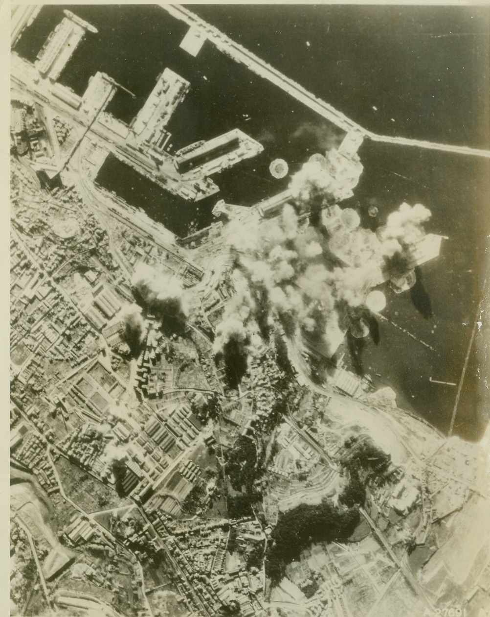 The Value of Precision Bombing, 4/24/1944. MARSEILLES, FRANCE -- Smoke billows upward from direct hits upon Nazi submarine pens at Marseilles, because of the bombardier's deadly aim and accuracy, only the objectives were hit, and the rest of the city remained intact. Thus, the months of training that bombardier cadets have undergone has resulted in a minimum of destruction to the parts of bombed cities in which there are no military objectives. Credit (US Army Air Forces Photo from ACME);