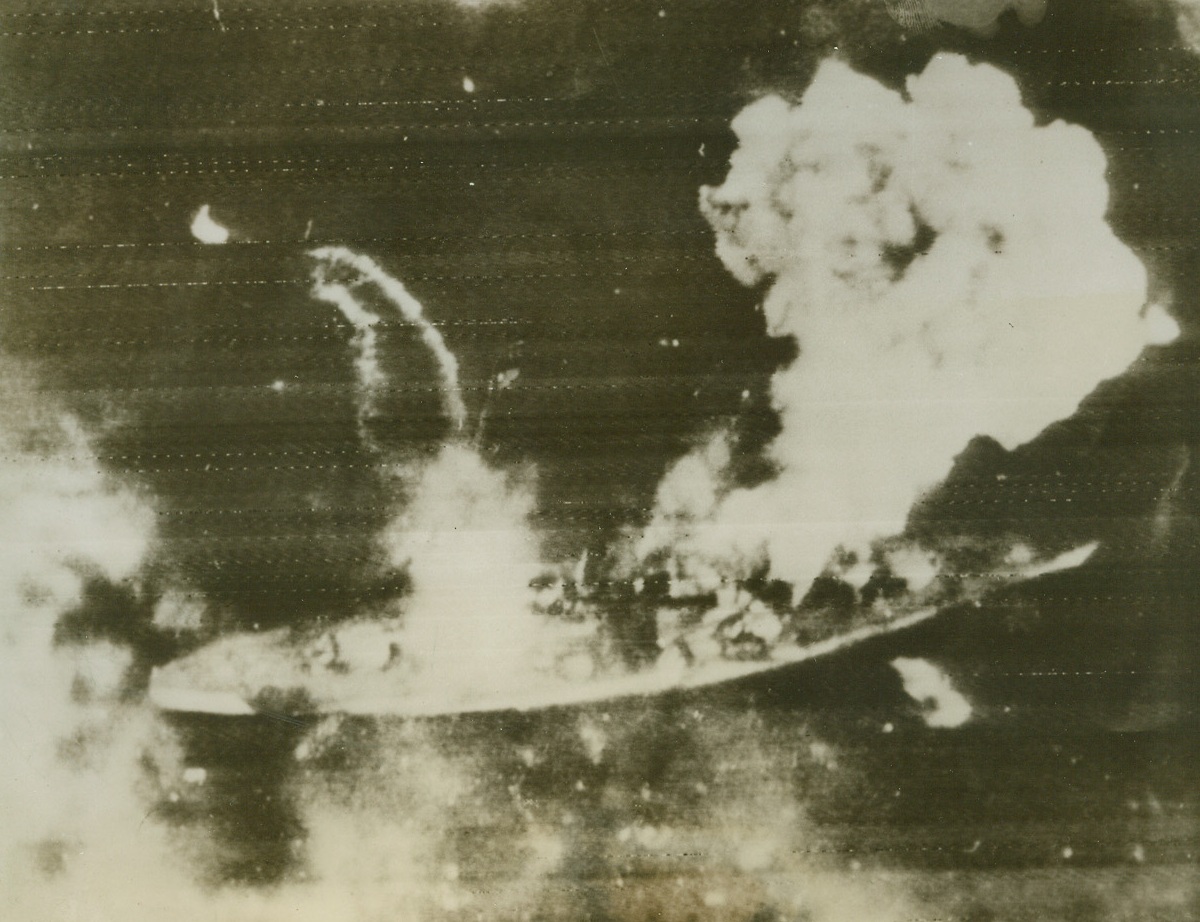 Battleship Tirpitz in Flames, 4/7/1944. NORWAY – Huge clouds of smoke rise from the German battleship Tirpitz after a hit near the bow. Wake of motorboat leaving ship shows faintly in left center. The British raided the ship April 3 at Alten Fjord, Norway. Hitler’s navy, what’s left of it, has yet to present itself, in any force, for battle.Credit Line (Acme Radiophoto);