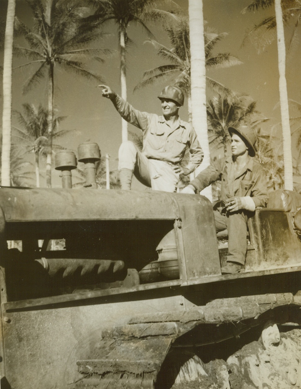 Bulldozer Direction, 4/22/1944. Los Negros Island – Brig. Gen. Hanford C. MacNider, of Mason City, IA.; former National Legion Commander, with Carpenter’s Mate First Class William Miller (seated) of Mineral Wells, Tex., pointing out the next piece of construction work to be done on this island. Gen. MacNider is in charge of all construction work and in less than a month under his supervision has had more than 30 miles of four-lane roads built by his men. Credit: Photo by ACME photographer Thomas L. Shafer for the War Picture Pool;