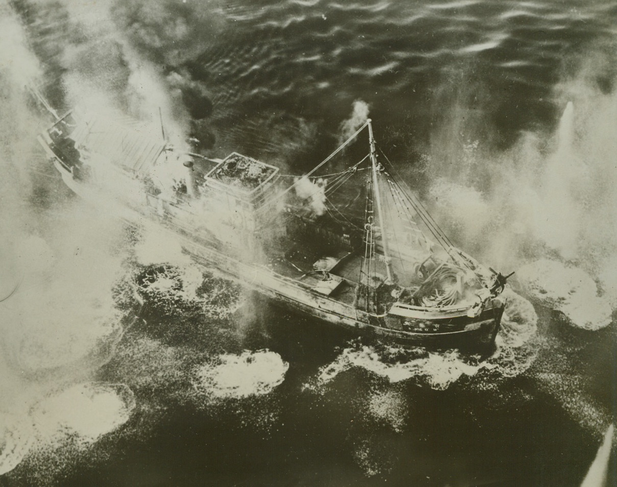 Jap Freighter Hit by U.S. Planes, 4/13/1944. Mergui, Burma – Scouring it with direct hits and near misses, planes of the U.S. Army 10th Air Force play havoc with this Jap freighter at Mergui, a port on the Andaman Sea. The near misses were so close that they, too, wrought destruction on the freighter, which Flounders amid rising water sprays. Credit: US Army official photo from ACME;