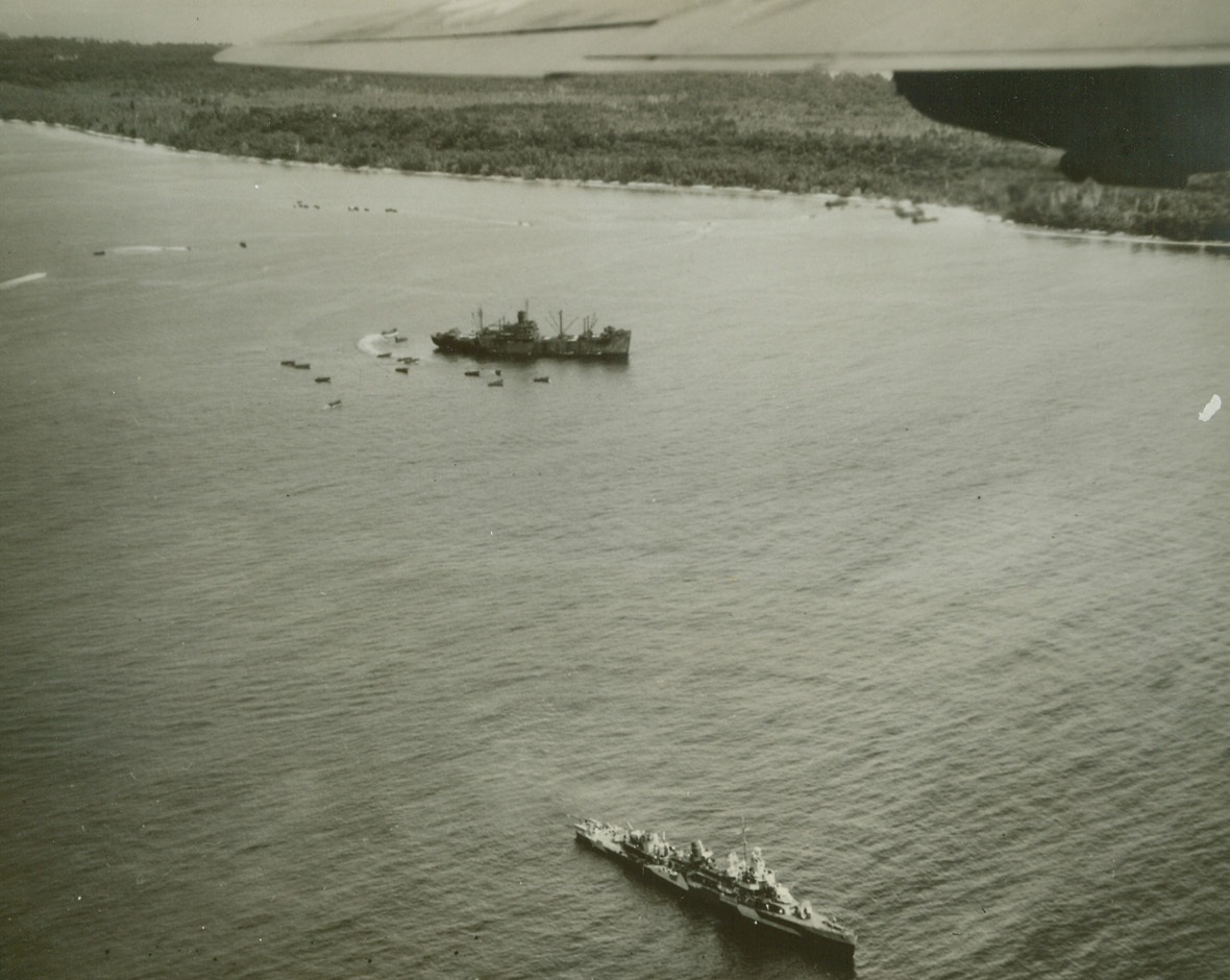 Yank “Triphibian” Attack”,  4/24/1944. This photo, just released in the U.S., shows American Marines hitting the beach at Jap-held Emirau, St. Matthias Island, while a U.S. destroyer, (lower center), keeps sharp lookout.  The landing was effected last March 19, while a heavy U.S. Navy task force dominated by battleships was pounding the Jap base at Kavieng, New Ireland, 34 miles away, to keep Nip planes grounded.Credit Line (U.S. Navy photo from ACME);