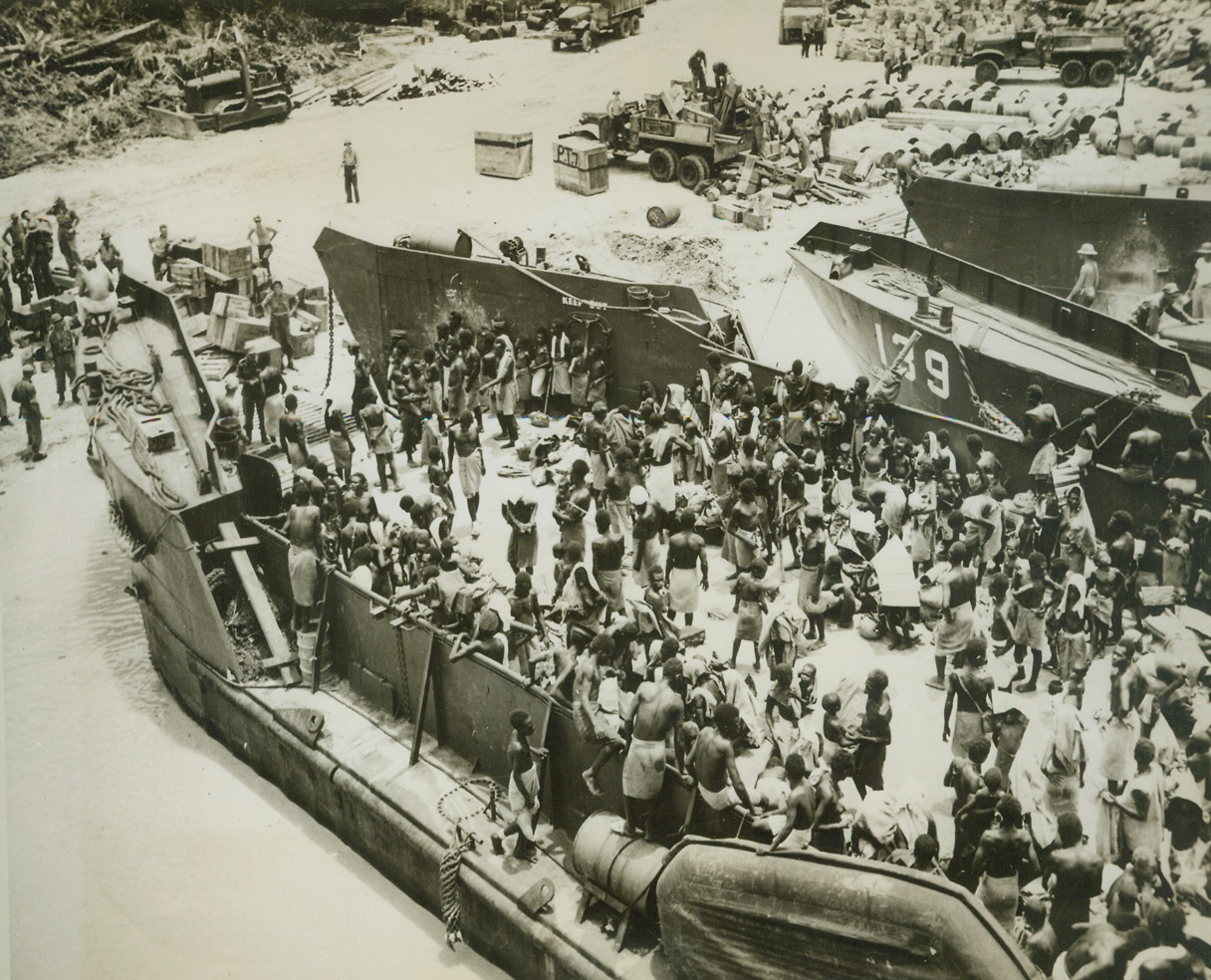 Solomons Exodus, 4/3/1944. Solomons: Hundreds of green islands natives are shown being removed on landing craft to safer zones pending the complete occupation of the Solomons objective.  The natives, ranging in ages from wrinkled-faced great-grand-fathers to babes in arms, present a strange scene of aboriginal domesticity to the war craft, about which they gathered. Credit (U.S. Navy official photo from ACME);