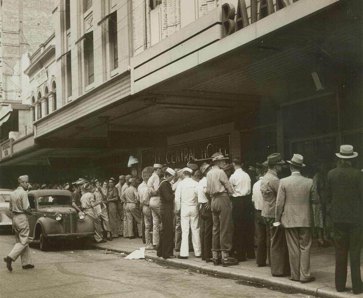 Yanks Shop for “Suds”, 4/4/1944. Brisbane, Aus. – American soldiers and sailors line up with civilians to buy their share of a slender stock of beer, outside a store in Brisbane.  Doors of the store open at 1:30 p.m. and remain open until the daily supply of beer is gone. The Yanks always manage to get their share of the “suds”. Credit line (ACME photo by Frank Prist, Jr. for the War Picture Pool);