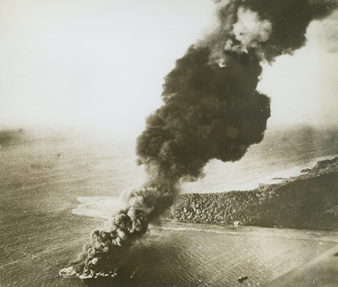 Tanker Goes Down at Truk, 4/7/1944. Truk—Rising from a seething bubble of oil and flame-topped sea water, a pillar of black smoke climbs skyward over Truk, marking the grave of a Japanese tanker.  The vessel was one of 23 enemy ships sent to the bottom by U.S. Navy task force raiders in the attack of February 16th and 17th. Credit line (official U.S. Navy photo from ACME);