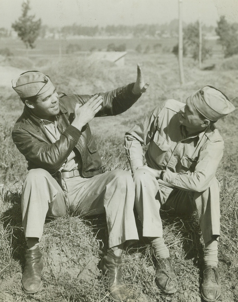 “I Did it This Way”, 4/10/1944. China – Expert airmen still wonder how he ever got the plane off the ground.  1st Lt. Owen F. Price (left), El Paso, Texas, is shown telling his buddy, 1st Lt. Duane McDonald, Eaton, Colorado, pilot, how he took off in a transport plane with a 12,000 pound load.  Normal load is much less. Credit line –WP- (ACME photo by Frank Cancellare War Pool , correspondent);