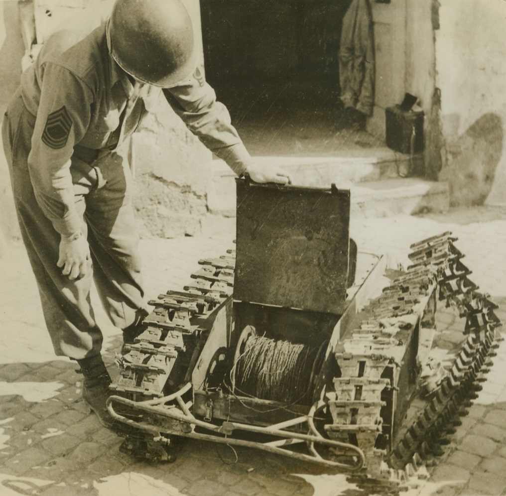 German “Doodlebug” Has a Sting, 4/27/1944. Italy - - An American soldier examines the inner works of a German “doodlebug” tank.  A miniature remote-control tank containing 250 pounds of explosives, the “bug” is 69 inches long including bumper, and 25 inches high.  Used against the allies in the Anzio area, it proved an easy mark for snipers. Credit line (ACME);
