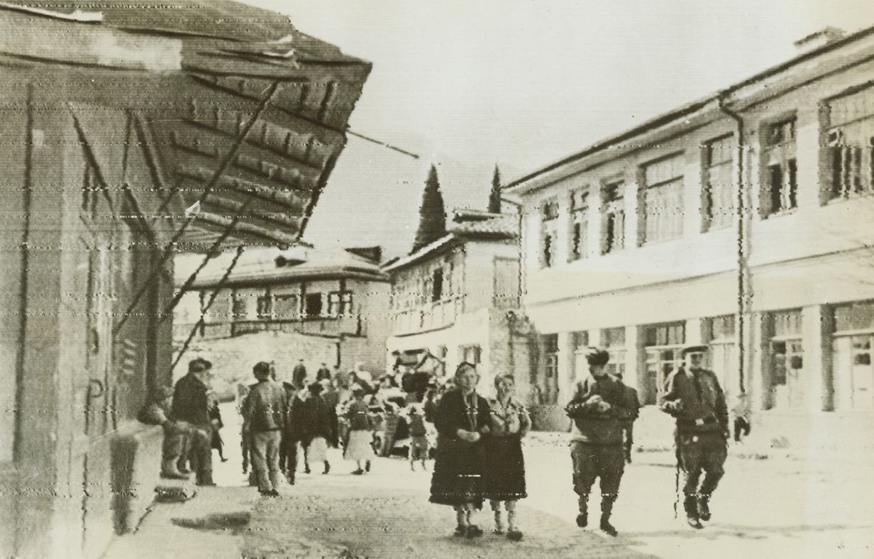 Russia Lives Anew, 4/26/1944. Gurzuf, Russia—In the warm spring sunlight, residents of Gurzuf walk down the town’s main streets where the buildings have been rebuilt by Russians returning to the Crimean town after Red forces had freed it of Nazi occupation. Though the war has meant a dark spot in their lives, Russians quickly return to normal living when the battle has passed them. (Passed by censors). Credit: ACME radiophoto.;