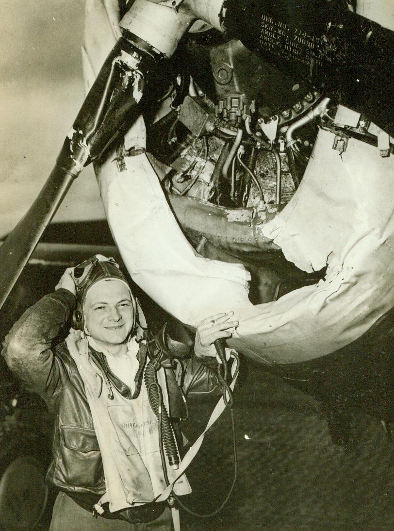 Looking Over the “Lawn Mower”, 4/19/1944. England - Lt. Dean R. Morehouse, of Williston, N.C., looks over his P-47 Thunderbolt Fighter at his base in England, after the ship had plowed through a row of 50-foot trees “like a lawn mower” during a mission over Germany. Here, Morehouse examines the engine cowling that was damaged and wonders how he was able to get home. He doesn’t know how many trees the ship mowed down, “I didn’t stop to count them” he said. Credit: USAAF photo thru OWI from ACME;