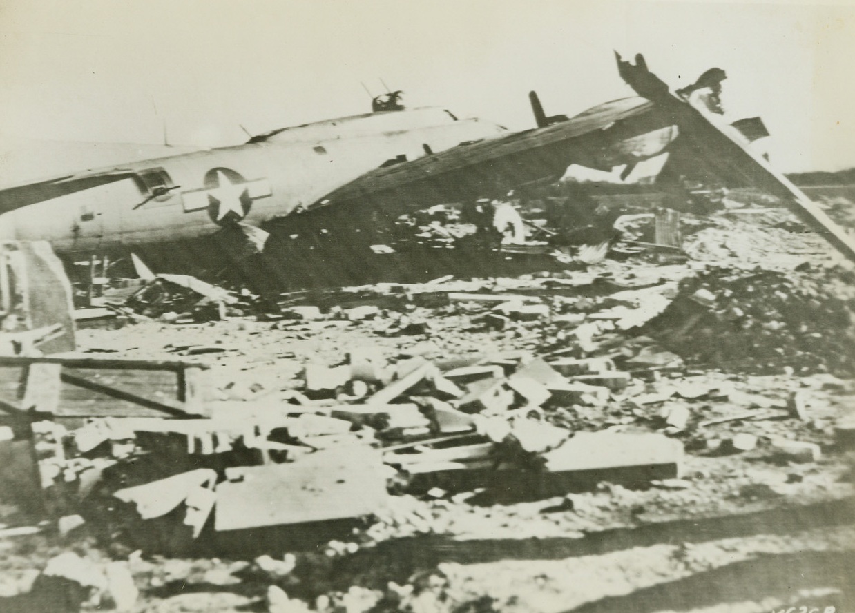 One Way To Stop ‘Em, 4/3/1944. England – This Flying Fortress of the U.S. Army Air Forces, returned from a raid over France where the ship was severely damaged, had to land without brakes and with half its controls shot away. A Nissen hut, the remains of which can be seen under the Fortress in the photo, served nicely in stopping the big bomber. No one was hurt. Credit: U.S. Signal Corps Radiotelephoto from ACME;