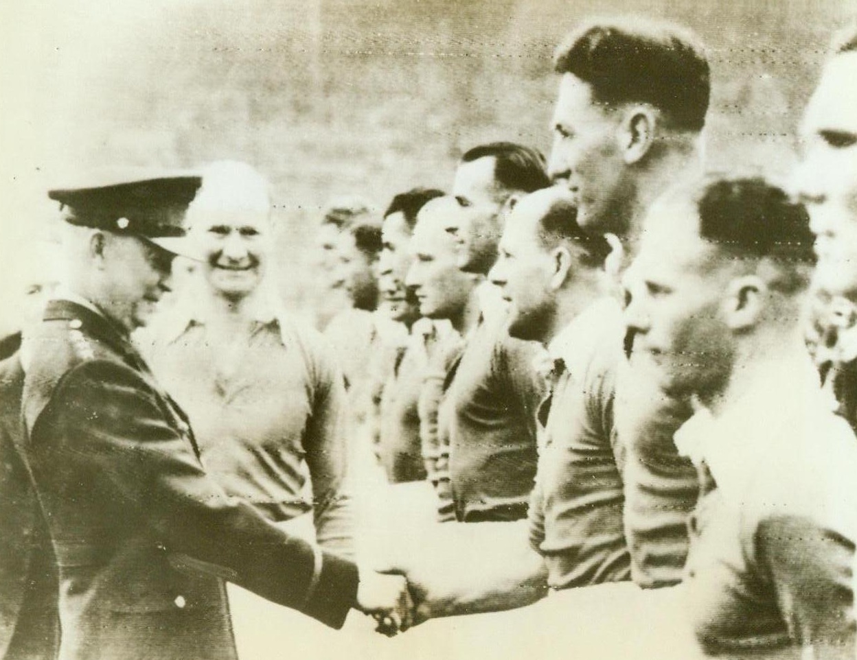 Ike” Calls Time-Out, 4/15/1944. Wembley, England—Gen. Dwight D. Eisenhower shakes hands with members of the Charlton team, winners in the Southern Cup Football final against Chelsea at Wembley Stadium. Gen. Eisenhower came as an unexpected guest to witness his first soccer game and the record wartime crowd of 85,000 gave him a thunderous ovation 4/15/44 (ACME Radiophoto);