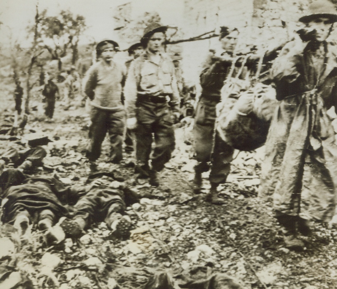 Gallant Poles Collect Their Dead, 5/24/1944. CASSINO, ITALY—After the capture of the long besieged Benedictine Monastery at Cassino by troops of the Allied Eighth Army, these Polish soldiers who fought the gallant fight with the Allies, sadly collect their comrades who were killed in the bitter and bloody battle. Here, they carry dead in from the field to a collecting point for burial. Today, Canadian troops of the Eighth Army smashed a gaping hole in the Adolf Hitler line between Pontecorvo and Aquino. Credit: U.S. ARMY RADIOTELEPHOTO FROM ACME.;