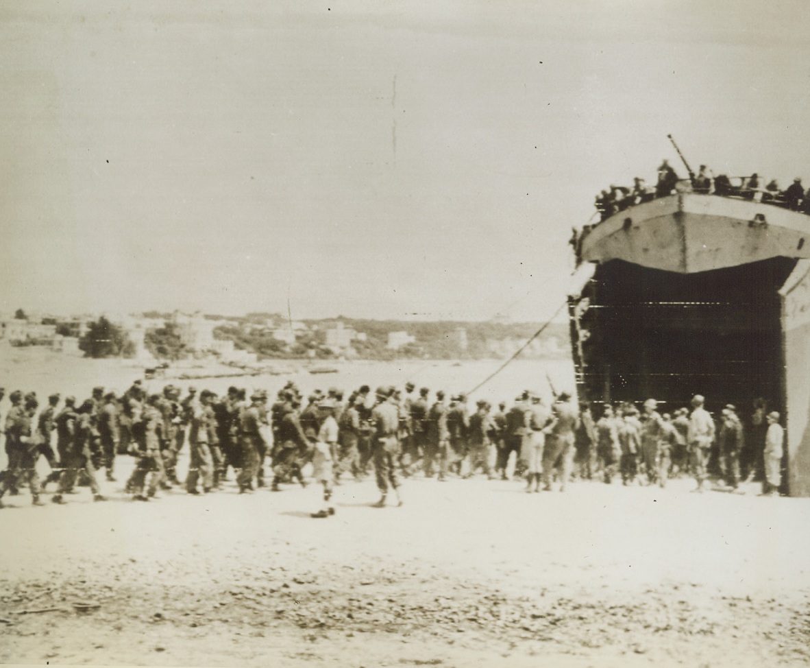 All Aboard for a POW Camp, 5/29/1944. ANZIO, ITALY—A long line of German prisoners from the Anzio beachhead tramp into the yawning mouth of an LST that will take them to another prisoner of war encampment. The luckless enemy soldiers were among the first caught in the swift tide of advancing Allied troops in Italy. Credit: U.S. ARMY RADIOTELEPHOTO FROM ACME.;