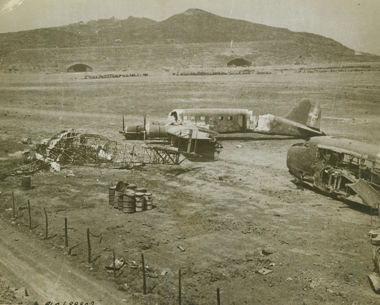 Didn’t Reach the Underground Hangers, 5/2/1944. PANTELLERIA-- A trio of Axis planes that were caught above ground during an Allied bombing of Pantelleria are crippled junk. Two entrances to the below surface hangers can be seen in the background. The sub-stratum plane facilities will serve the Allies well, on the conquered island. Credit: ACME.;
