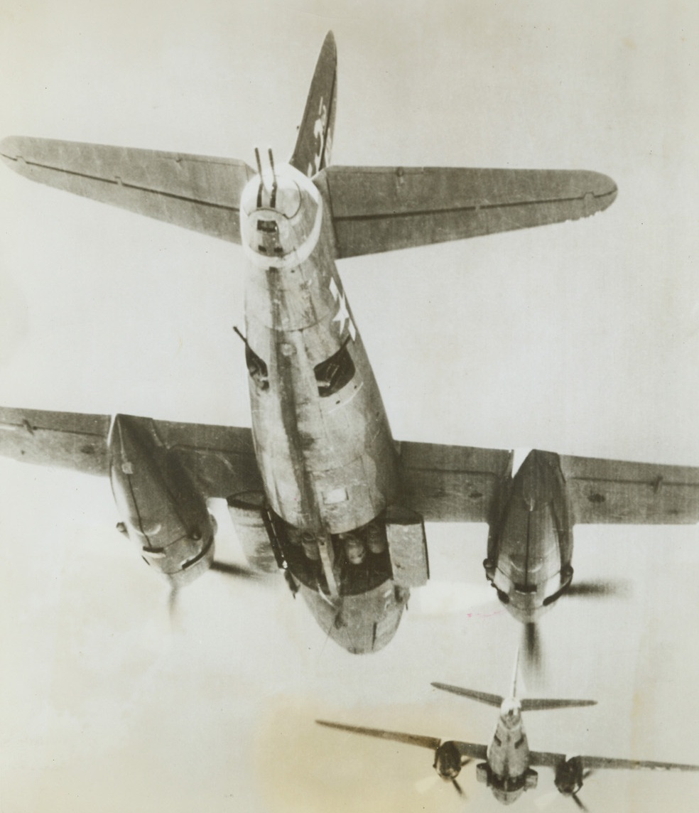 BOMBS AWAY, 5/20/1944.ITALY—In this unusual photo bombs can be seen through the open bomb bay doors of U.S. Army B-26 Marauders just before they went hurtling down through space on a railroad bridge south of Florence, Italy. Bombs cut the rail line used by the Nazis to supply their Cassino and Anzio fronts.Credit: USAAF photo from Acme;