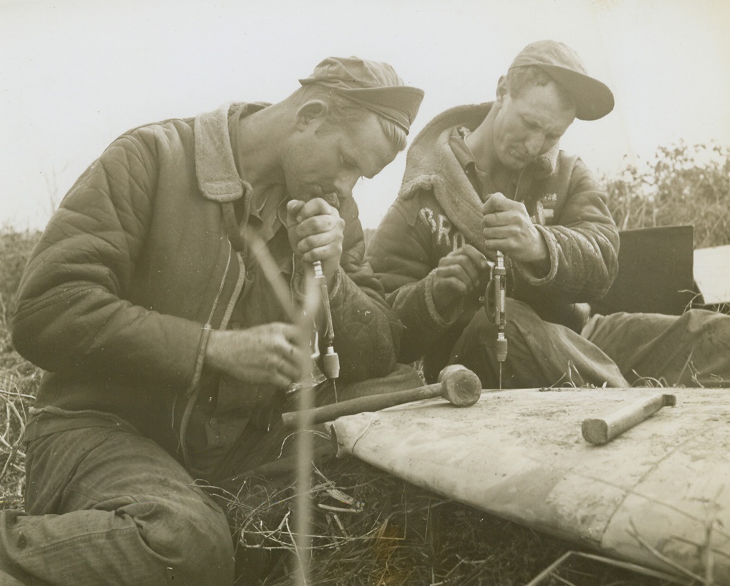 SALVAGE SOLDIERS, 5/17/1944. NETTUNO, ITALY—S/Sgt. Robert S. Lockett, of Dallas, Tex., and S/Sgt. Lewis Brooks, of Gunter, Tex., salvage parts of a Spitfire at Nettuno airfield.Credit: Acme photo by Charles Seawood for the War Picture Pool;