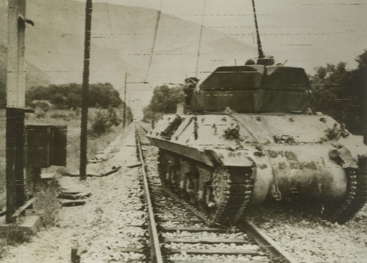 HEADED TO BLAST TRAPPED NAZIS, 5/25/1944. FONDI, ITALY—An American M-10 tank destroyer doubles as an anti-personnel artillery piece, as it moves up to blast Germans trapped in the Mont Orso tunnel of the west coast electric railway near Fondi. Today, U.S. forces of the Fifth Army have moved up to join troops from the Anzio front at a point near Lake Fogliano. Credit: Army Radiotelephoto from Acme;