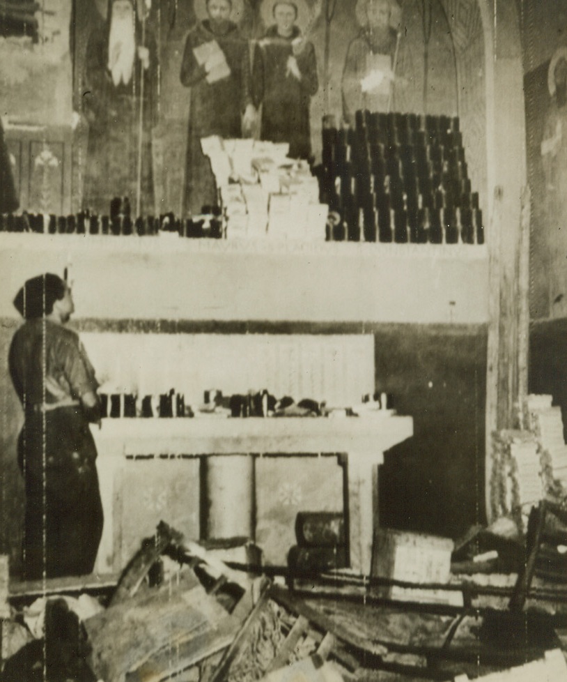 DESECRATION, 5/26/1944. ITALY—Nazis, with no apparent regard for religious significance, stored rations in the Montecassino Abbey. A Polish soldier, candle in hand, looks at paintings of Saints, partly concealed by the German food, above the altar. Credit: Army Radiotelephoto from Acme;