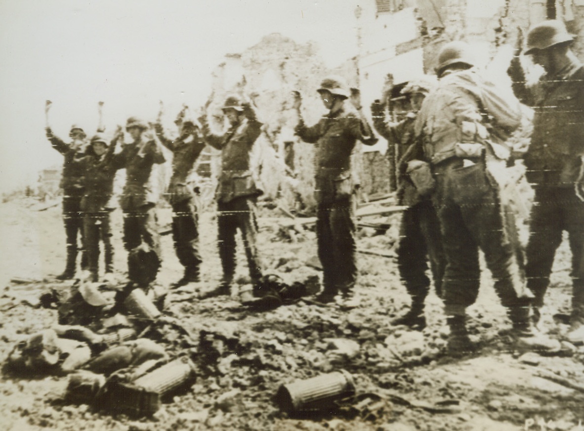 Trapped Nazis, 5/29/1944. CISTERNA, ITALY – Trapped in Cisterna by Infantrymen of the Allied Fifth Army, these Nazi prisoners raise their hands high as our warriors search them for hidden weapons. All of the soldiers in the group were sniping from a ruined building until they ran out of ammunition – then they surrendered. The gear the captives carried with them lies in foreground. Credit Line (U.S. Army Radiotelephoto from ACME);