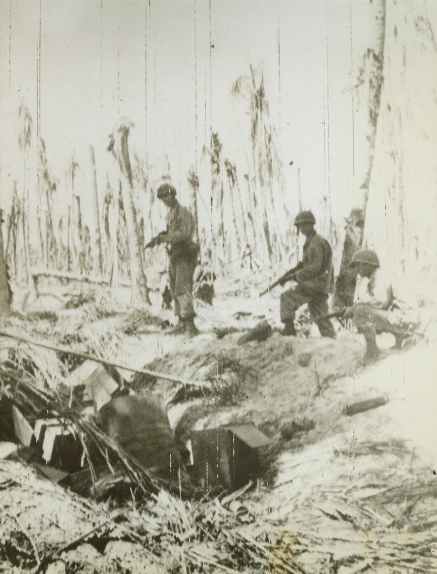 Trapping Nips on Wakde, 5/23/1944. Three U.S. Infantrymen, their guns held ready, advance cautiously on one of the few remaining pockets of Jap resistance on Wakde Island, off the coast of Dutch New Guinea – a battered pillbox. Today, Yanks are in full possession of the area and are using its airfield – a big step nearer the Philippines. Credit: ACME photo by Frank Prist for the War Picture Pool via Army Radiotelephoto;