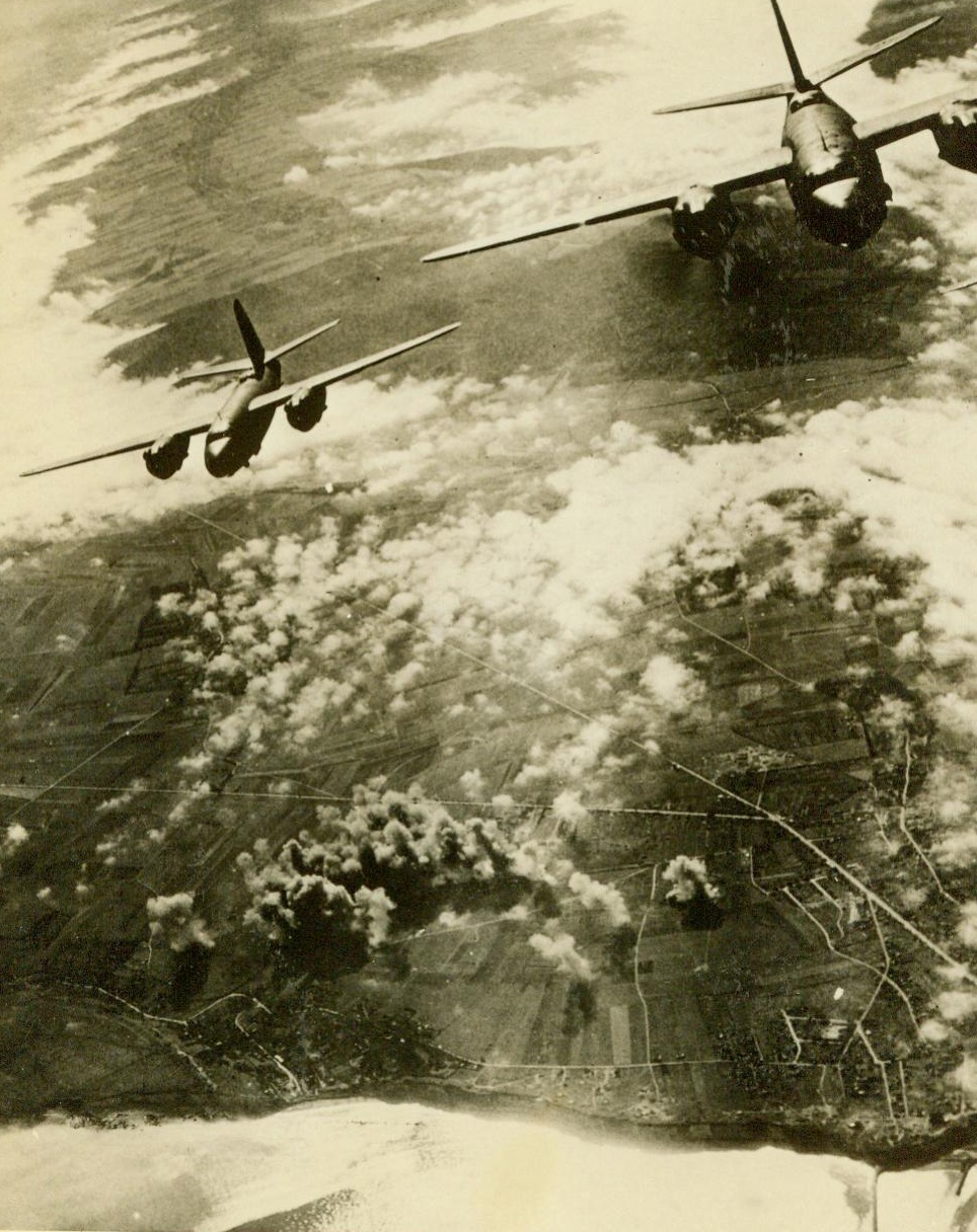 Mission Accomplished--Homeward Bound, 5/3/1944. Over France -- Dusty clouds far below tell the tale of a mission accomplished, and these two B-26 Marauders head for home with empty bomb racks. These Marauders have been carrying a great deal of the load of pre-invasion raids on occupied France and important industrial and communications centers in Germany. Some of these planes are based in England, and others in Sardinia and Italy, where French airmen constitute their crews. A noticeable weakness in enemy land defense has been accomplished through these tremendous Allied air attacks. Credit: Official USAAF photo from ACME;