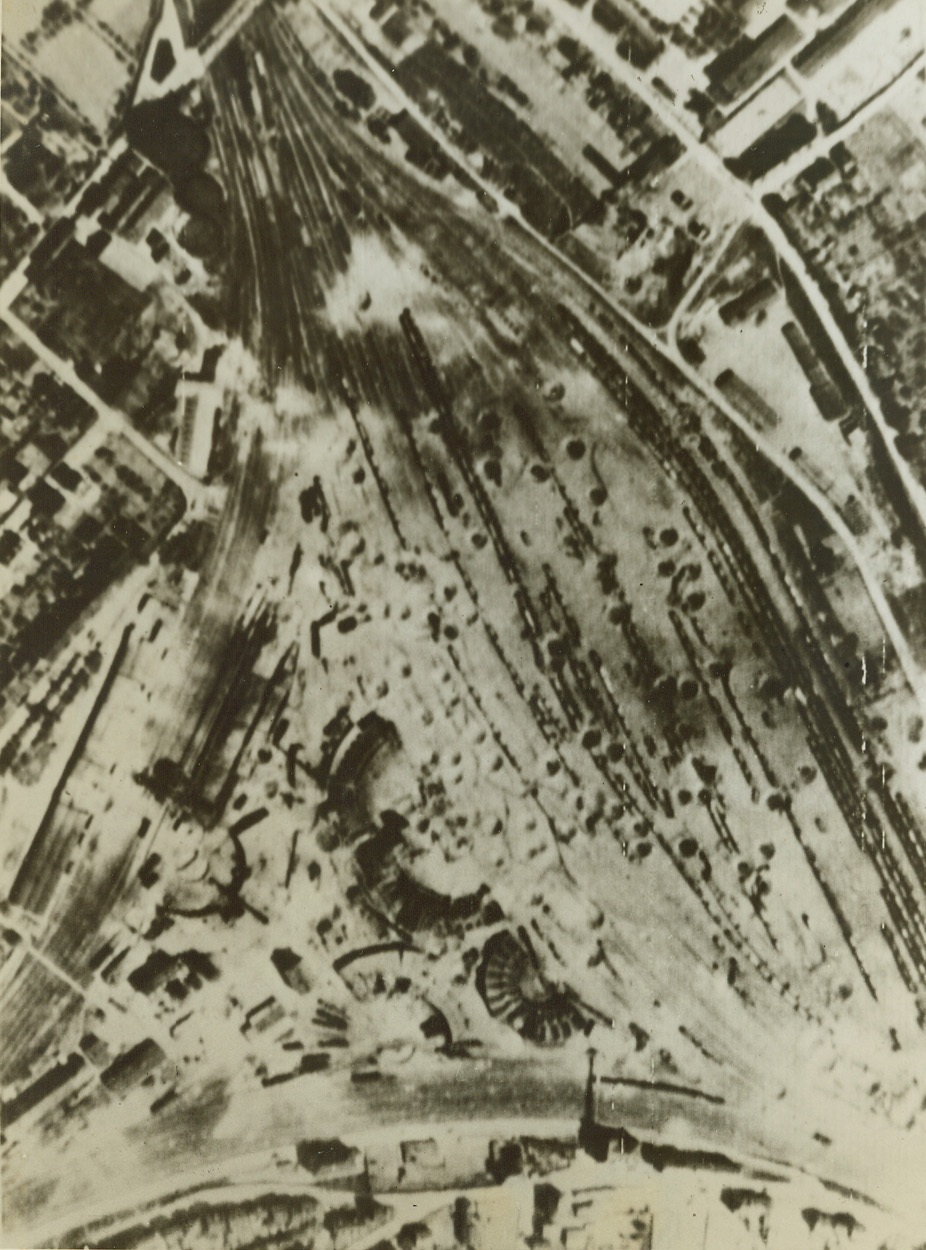 More USAAF Precision Bombing, 5/6/1944. Metz, France – These railroad yards at Metz are pitted with bomb craters following another raid by U.S. Flying Fortresses and Liberators on May 1. Faultless precision bombing resulted in direct hits on tracks, rolling stock and roundhouses at the yards—heavy blows to the already crippled German transportation facilities. Metz was just one of six Nazi rail yards hit by U.S. planes on the afternoon of May 1. Passed by censor. Credit: Signal Corps photo from ACME;